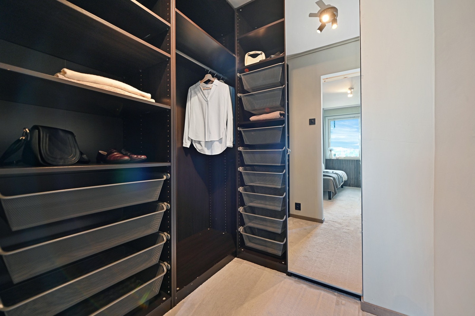 Innerst i soverommet har du også tilgang til et eget garderoberom med flott innredning, med god plass til det du trenger av klær, vesker og sko. Garderobeskapene medfølger. Galleribilde