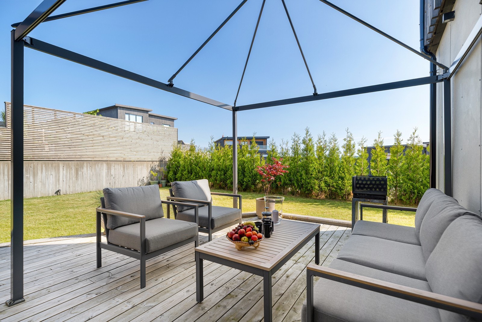 Hagen er omkranset av hekk, plen og terrasse der du kan nyte solfylte dager i rolige omgivelser Galleribilde