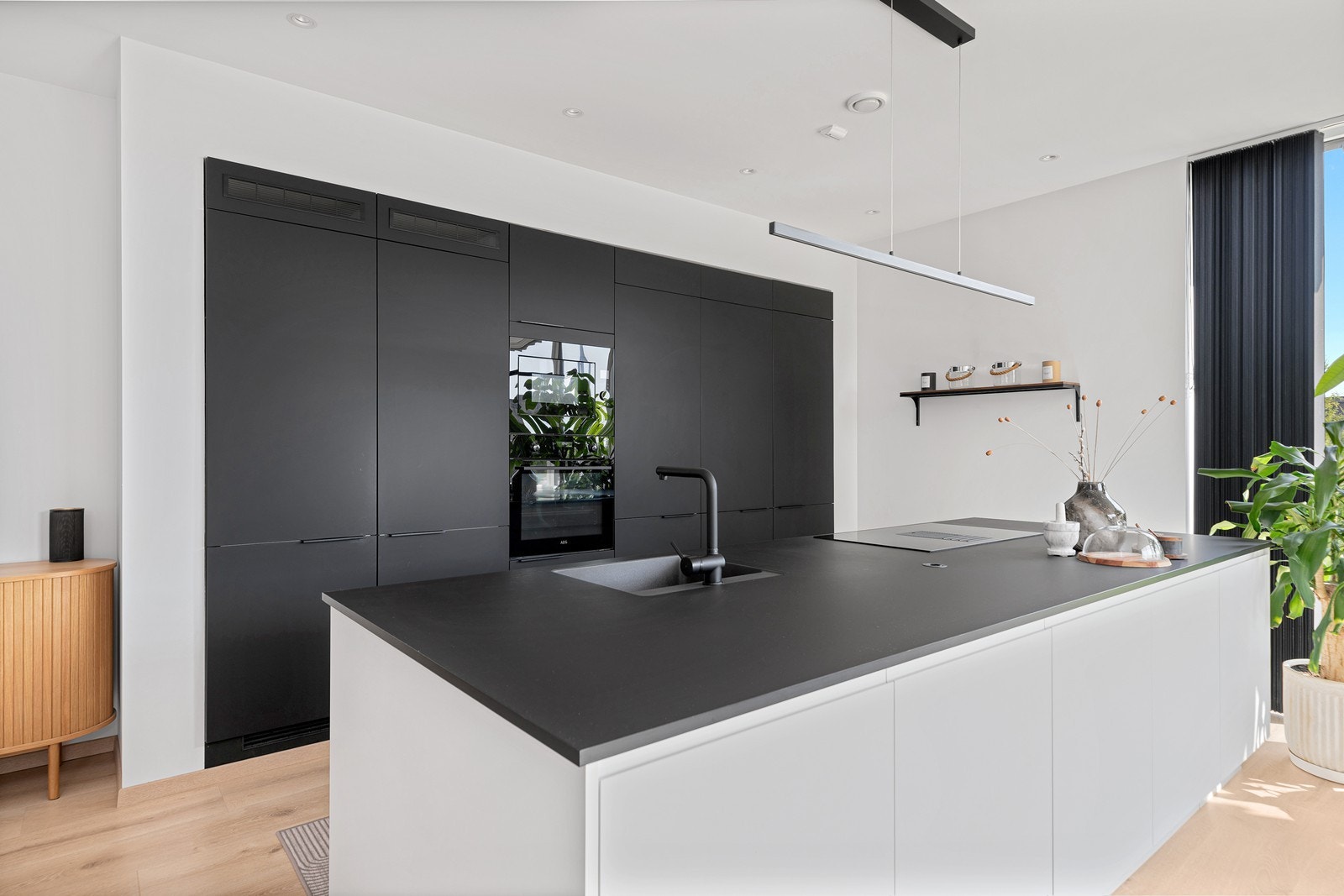 Kjøkkenet er et delikat Strai-kjøkken med stor kjøkkenøy, integrerte hvitevarer og god belysning Galleribilde