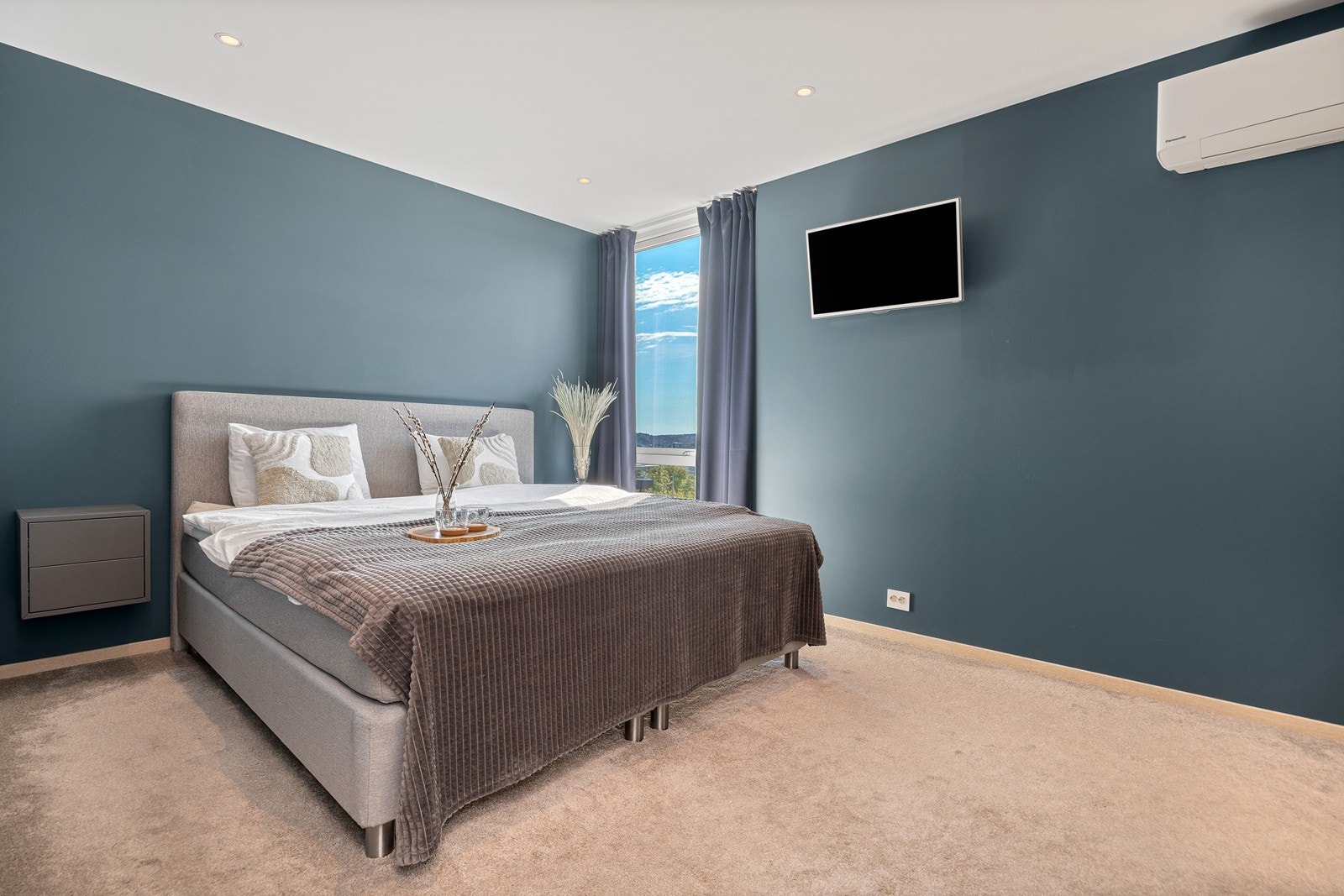 Hovedsoverommet har gulvteppe og malte gipsvegger i lun blåfarge Galleribilde