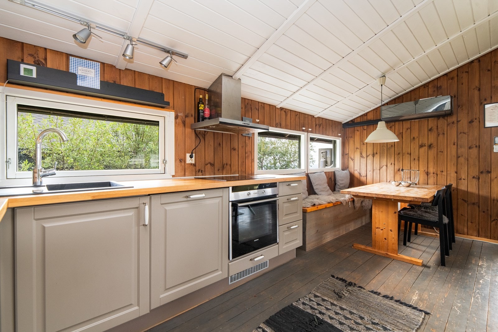 Det er en koselig spiseplass inntil kjøkkenet, med plassbygget sittebenk og langbord. Integrerte hvitevarer som platetopp, stekeovn, oppvaskmaskin og kjøl/fryseskap, og over kokesonen er det ventilator med avtrekk ut. Galleribilde