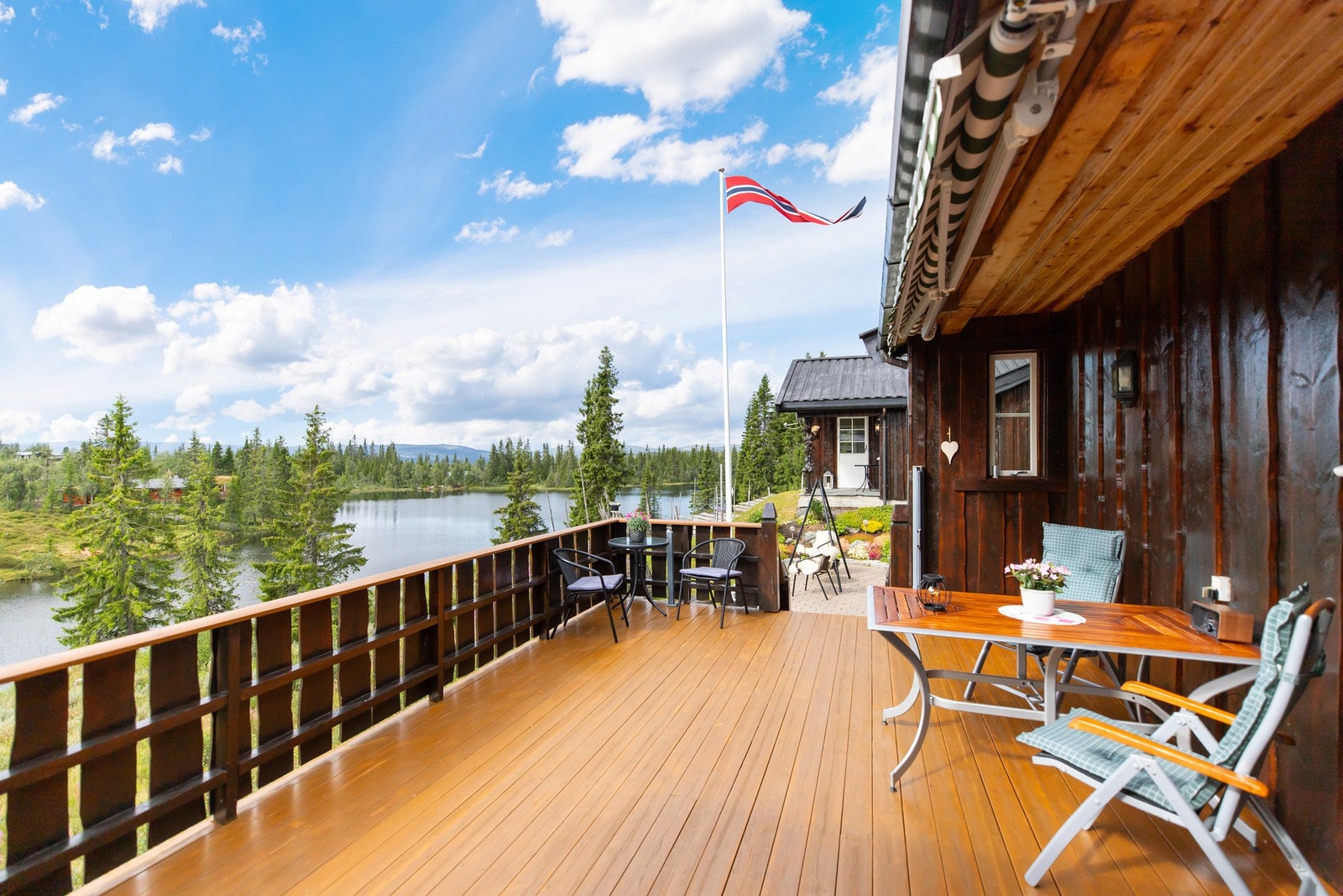 Romslig terrasse med utgang fra stue og spisestue, samt trapp ned til uteområdet Galleribilde
