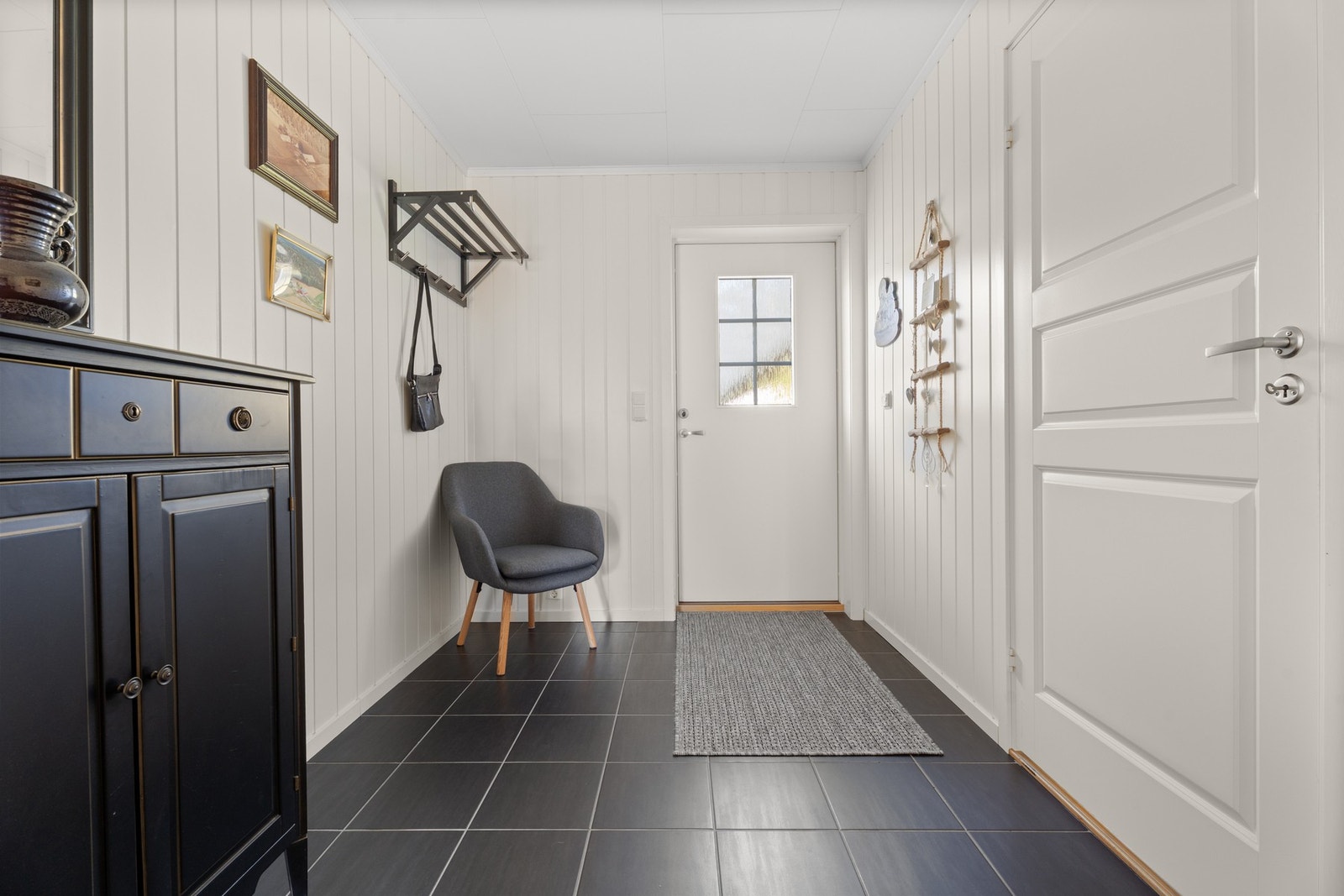 Flislagt gulv i entréen - slitesterkt og enkelt å holde rent. Her er det også varme i gulvet. Galleribilde