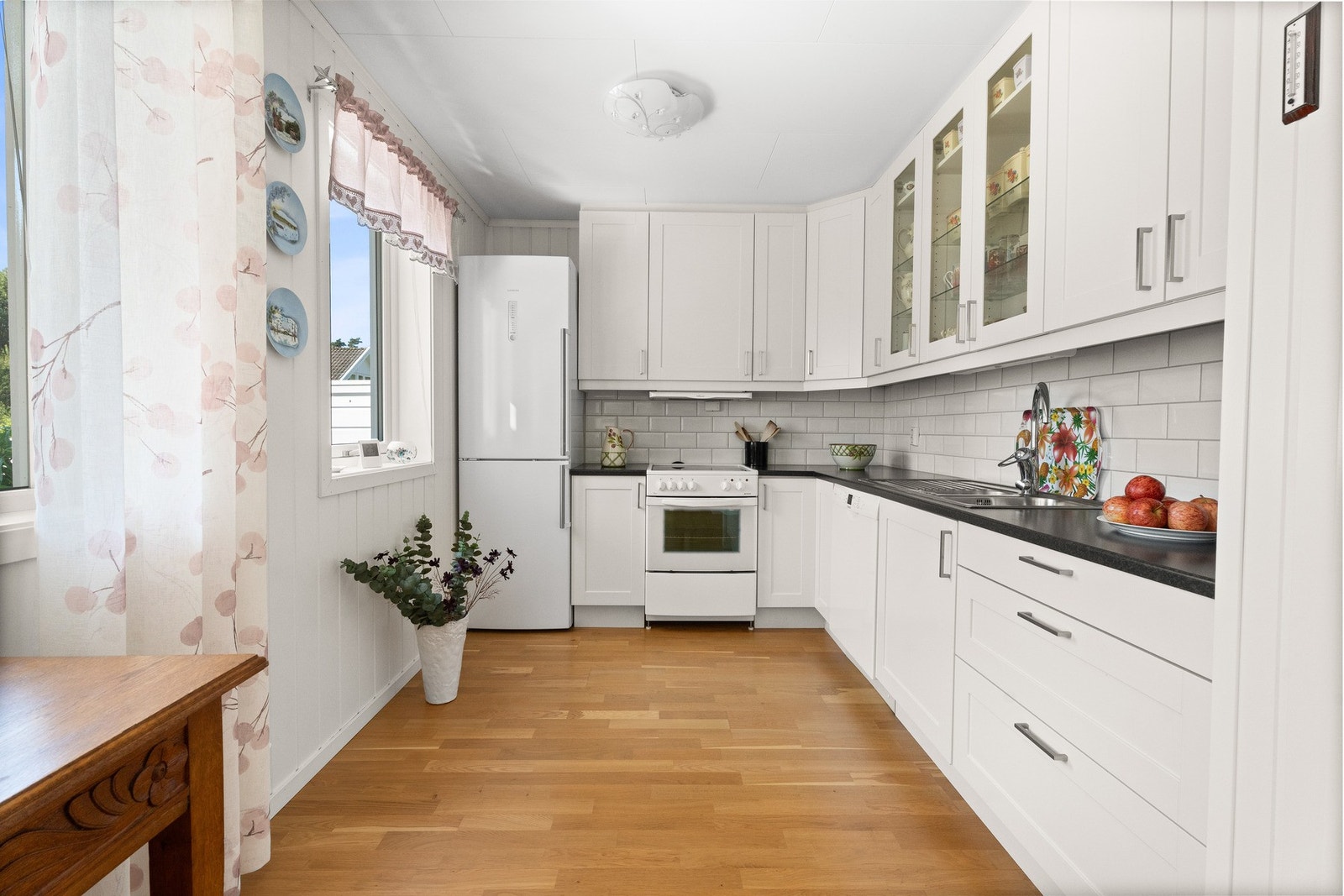 Leiligheten har et pent kjøkken med hvite, profilerte fronter. Galleribilde