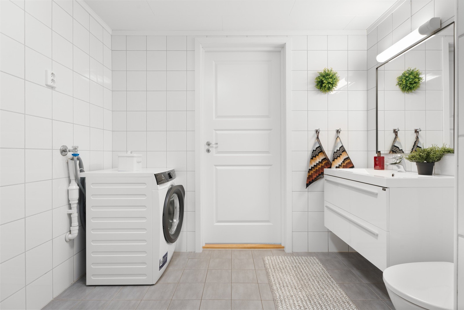 Badet har fliser på vegger og gulv, og det er varme i gulvet. Galleribilde