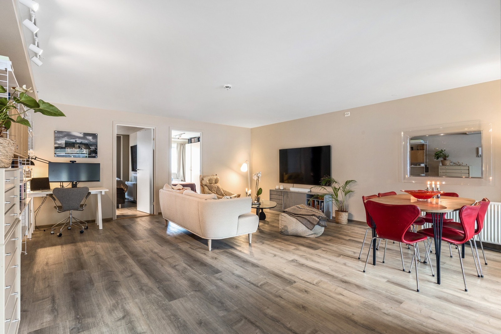 En lys og romslig stue med god plass til sofagruppe og spisebord med tilhørende møblement Galleribilde