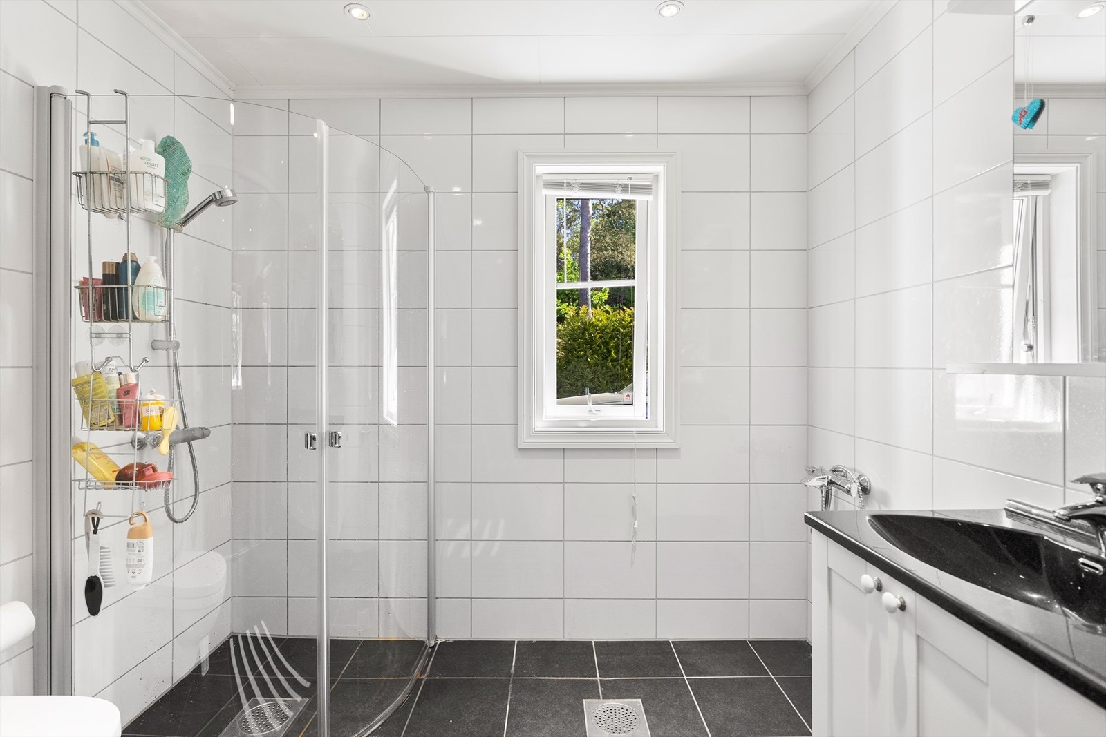 Badet inneholder dusjbue med foldedører, vegghengt toalett og dobbel servant. Baderomsmøbler med profilerte fronter. Galleribilde