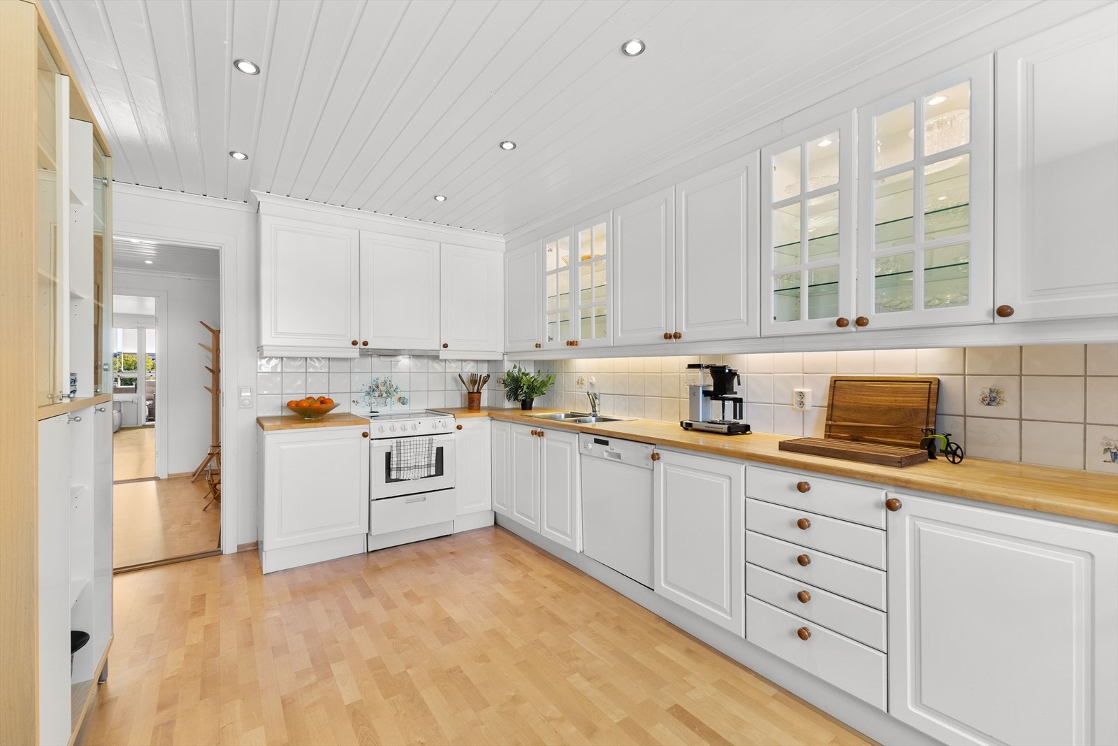 Stilrent kjøkken med profilerte- og enkelte glassfronter og heltre benkeplate. Galleribilde