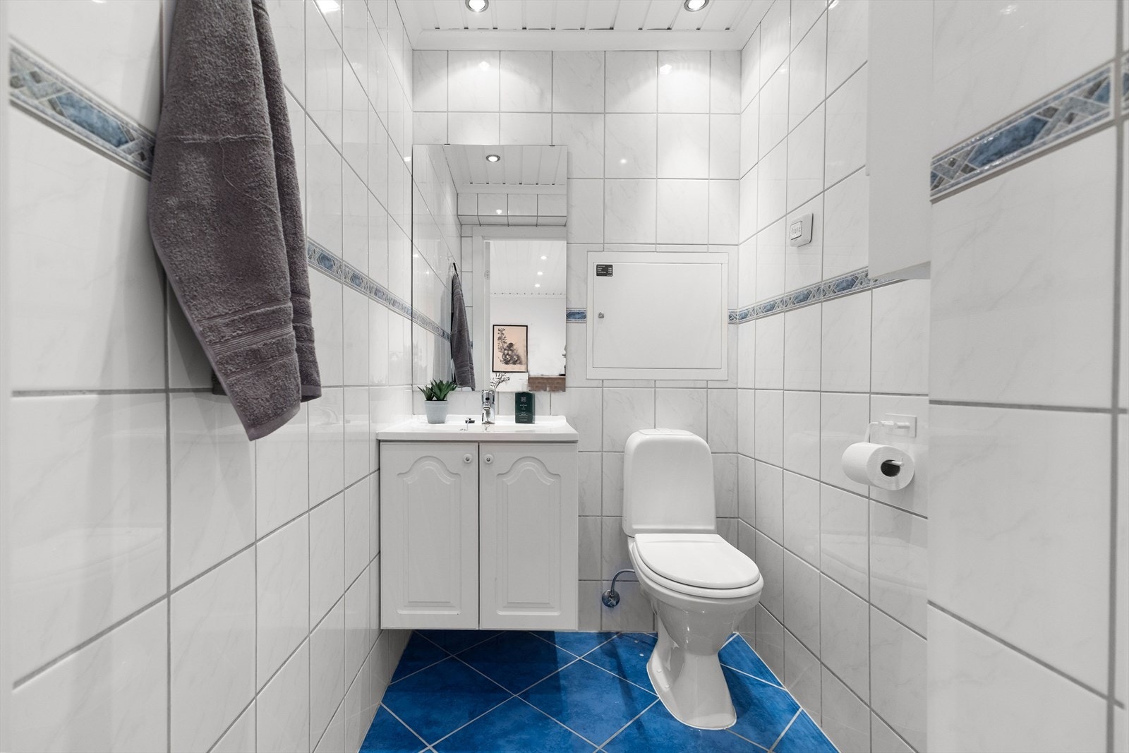 Separat wc med innredning bestående av nedfelt vask, benkeskap med profilerte dører og spotter i tak. Galleribilde