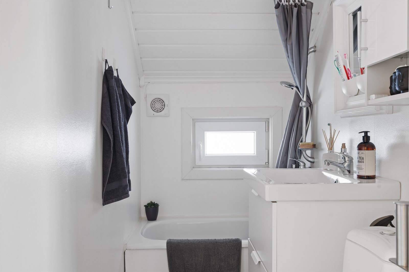 Boligens bad har belegg på gulv og og det er montert stråleovn på vegg som varmekilde. Badet er videre utstyrt med servantinnredning, wc på sokkel og badekar med dusjmuligheter Galleribilde