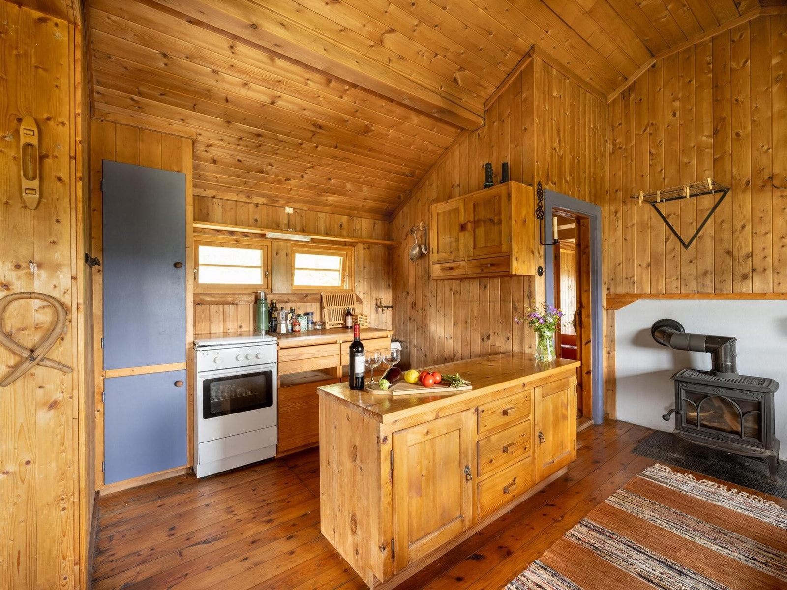 Kjøkkeninnredning med benkeskap, overskap, høyskap og kjøkkenøy Galleribilde