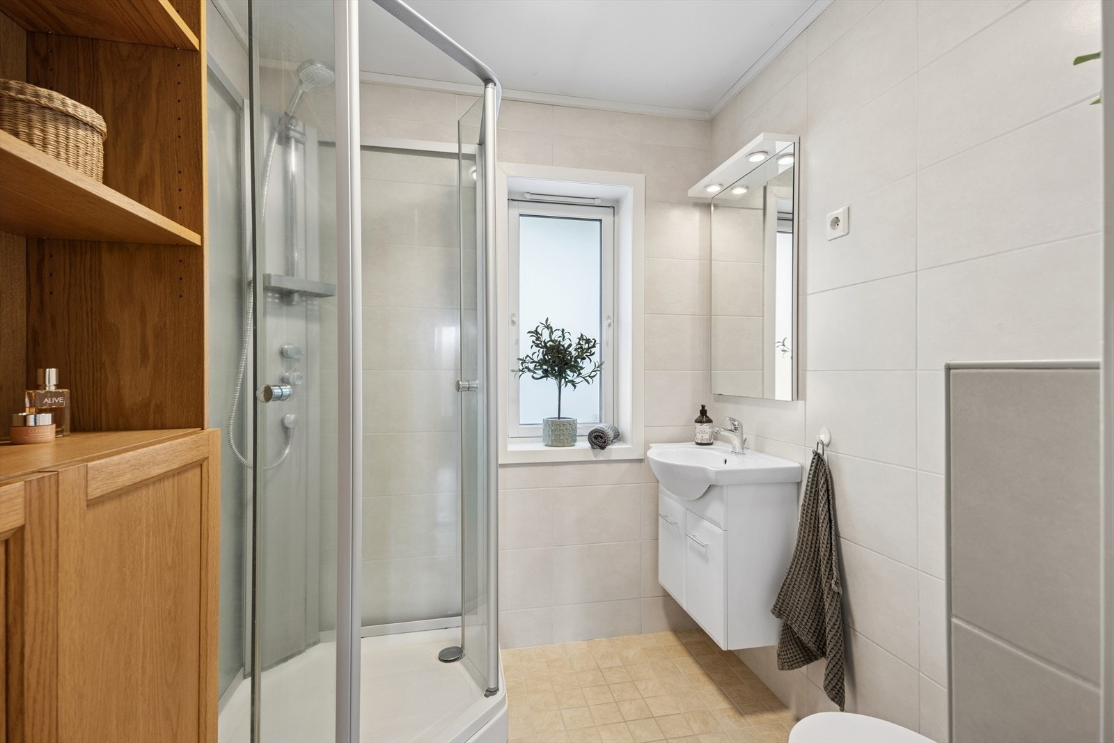 Bad er opplyst totalrenovert i regi av tidligere eier i 2009. Badet er flislagt med gulvvarme. Rommet har baderomsinnredning med heldekkende servant og underskap med dører, veggmontert toalett og dusjkabinett. Galleribilde