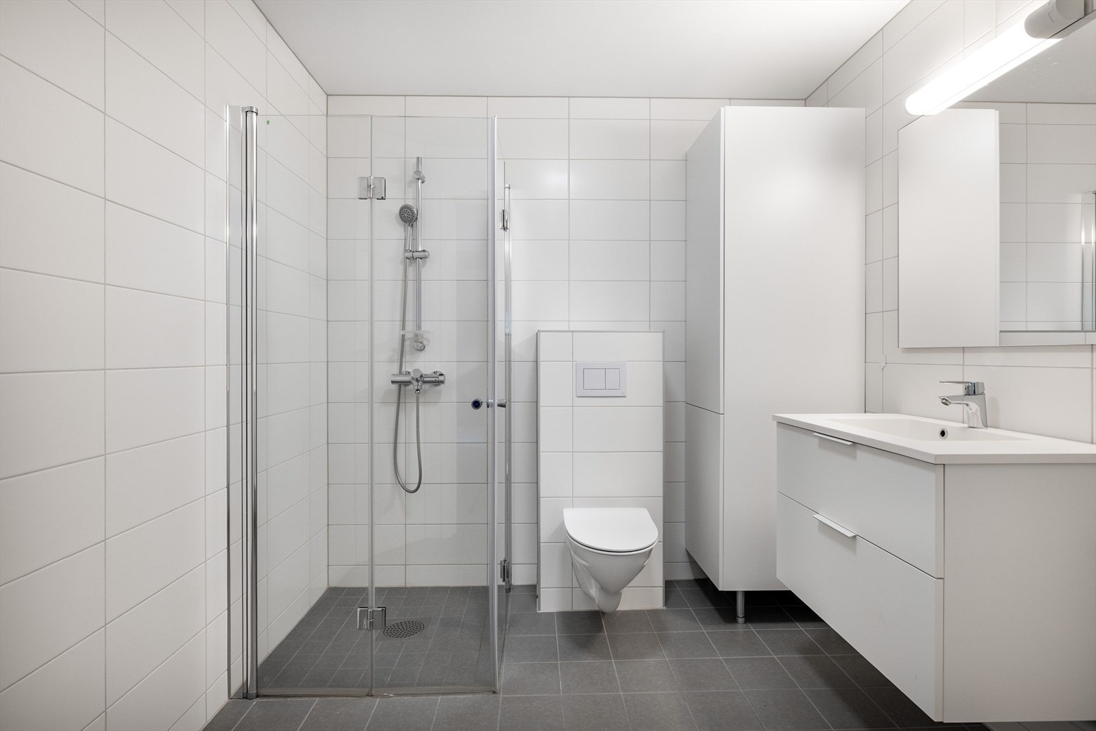 Tidløst bad med fliser på gulv og vegger, vannbåren gulvvarme og balansert ventilasjon. Det er plass og opplegg for vaskemaskin og tørketrommel over om ønskelig. Galleribilde