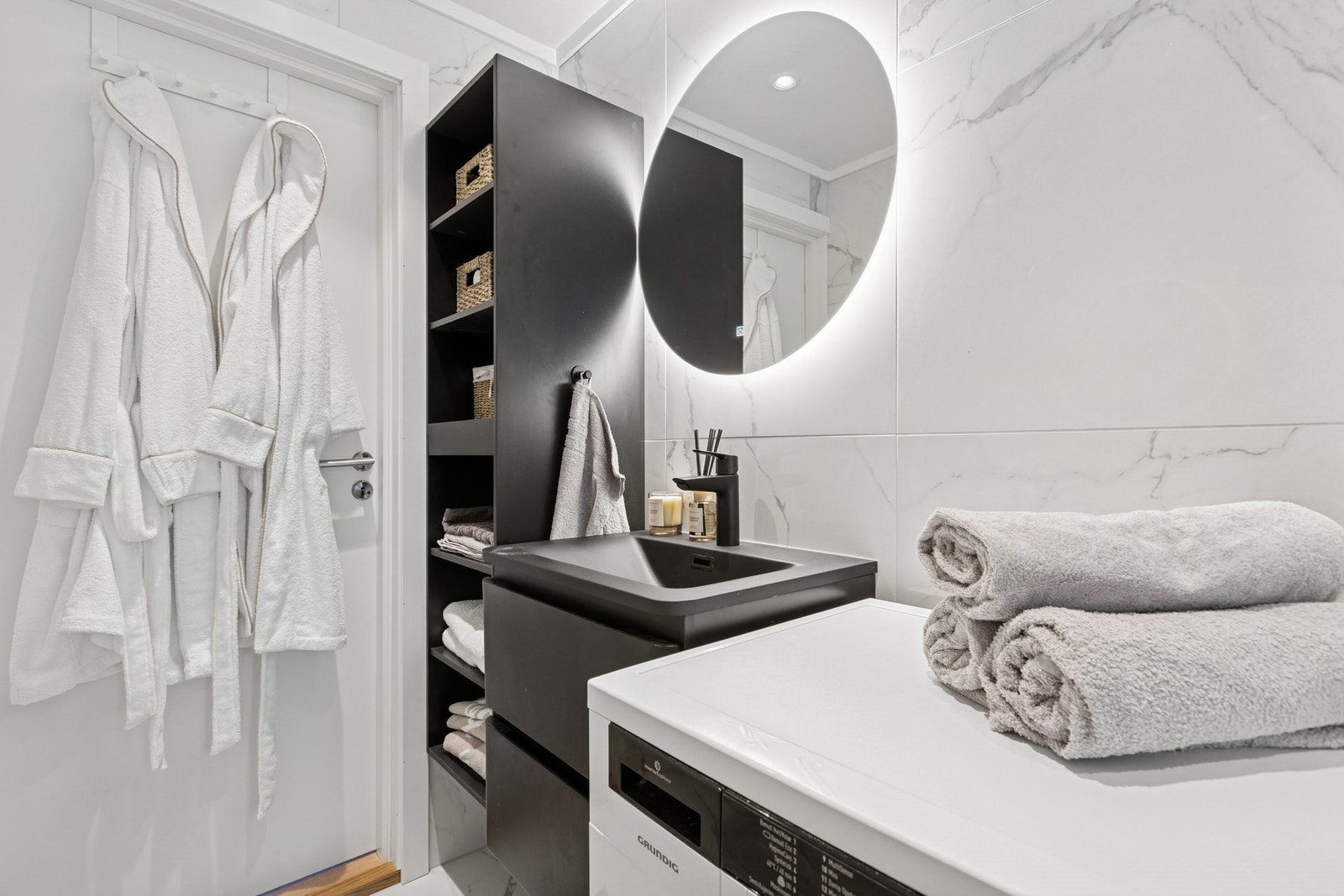 Badet ble totalrenovert i 2025. Rommet har speil med egen belysning, store fliser, gulvvarme, opplegg for vaskemaskin og vegghengt toalett. Galleribilde