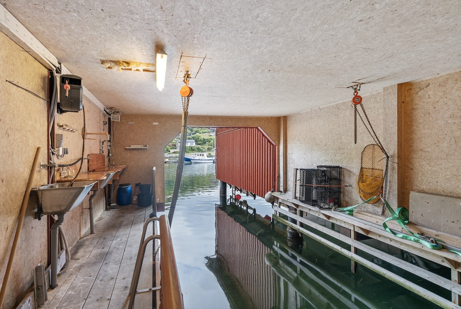 Båthus med ca. 3,5 meter bredde. Her har man også arbeidsbenk og utslagsvask med påkobling til vann med vannslange til vannpost utenfor. Galleribilde