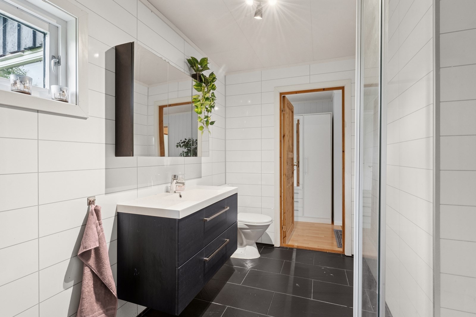 Badet er stilfull, moderne og godt utstyrt med baderomsinnredning,. Dusjkabinett. gulvmontert toalett. Opplegg for vaskemaskin. Galleribilde