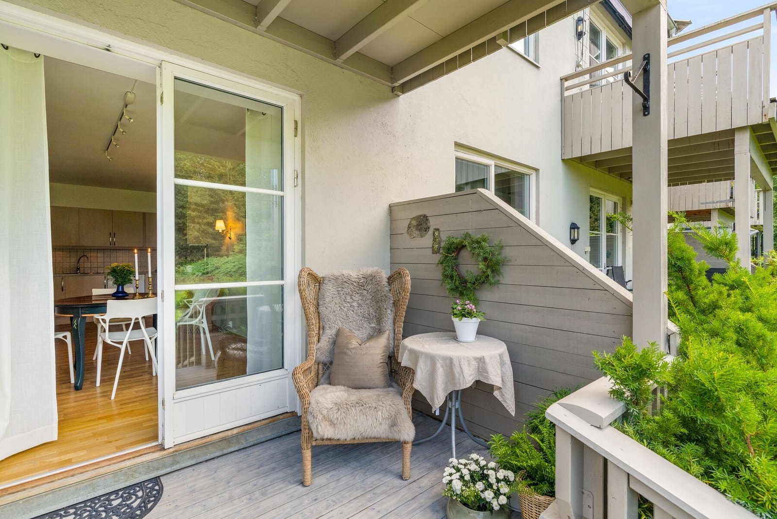 Fra spisestuen er det utgang til balkongen omgitt av frodig grønt beplantning. Galleribilde