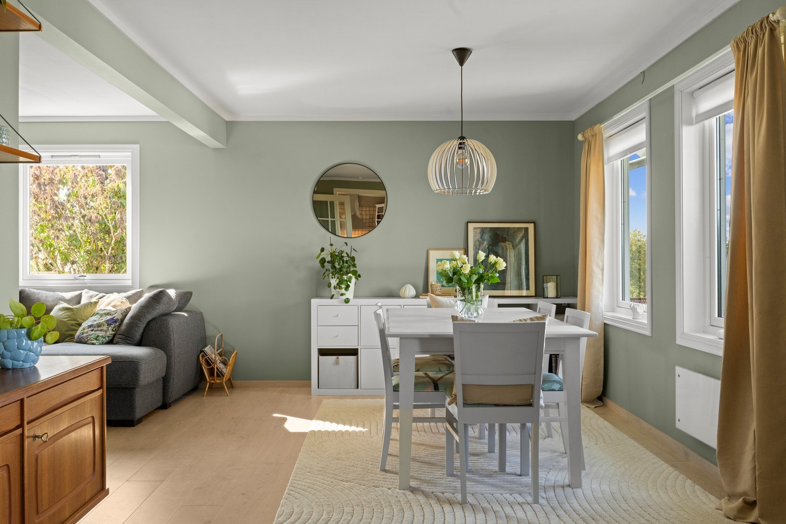 Stuen er i vinkel og gir naturlige soner for spisebord og sofakrok Galleribilde