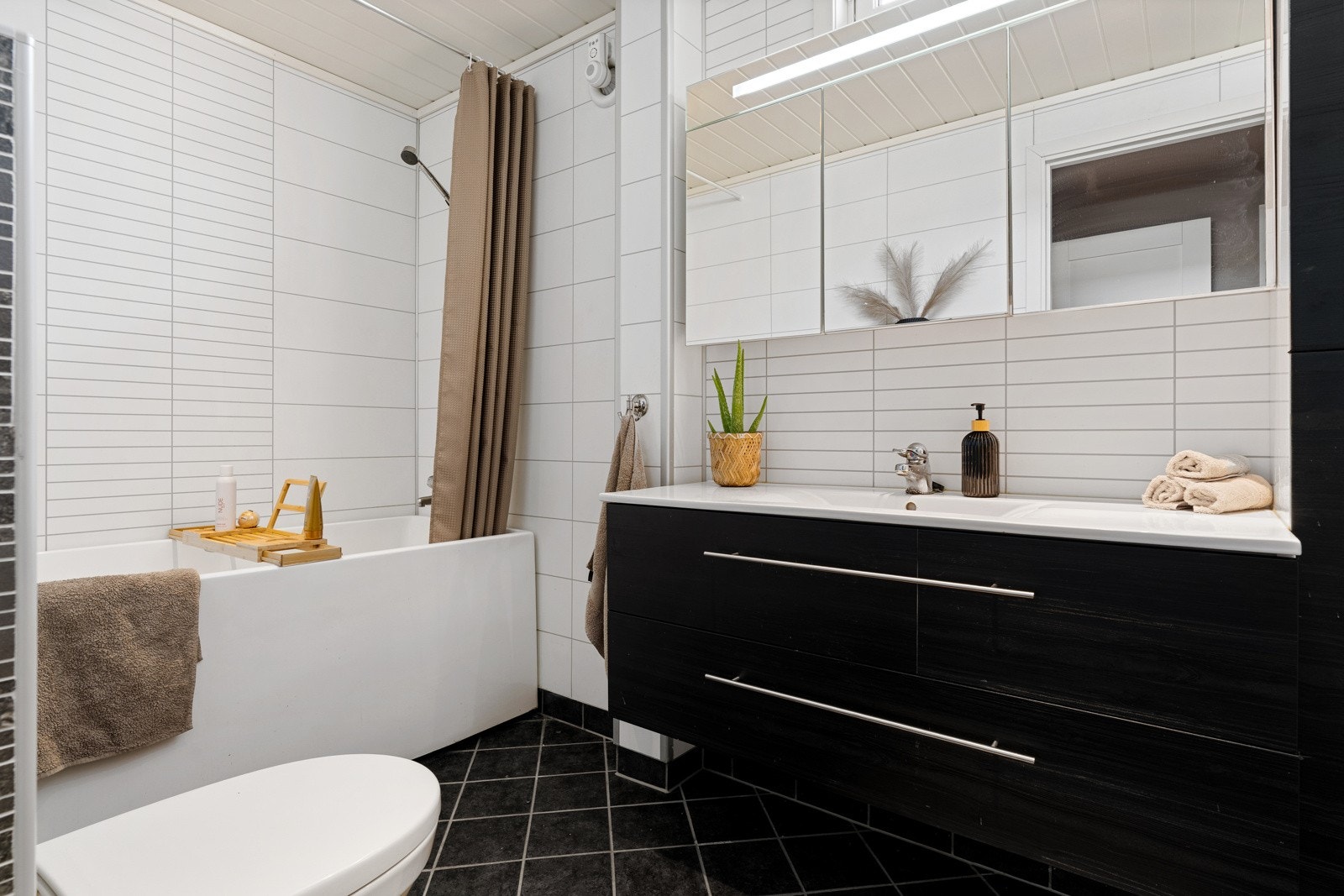 Badet ble oppgradert i 2012 med flislagt gulv og våtromsplater på vegger. Øvrig innredning består av badekar, toalett, speilskap og et romslig baderomsmøbel med mye oppbevaringsplass. Galleribilde