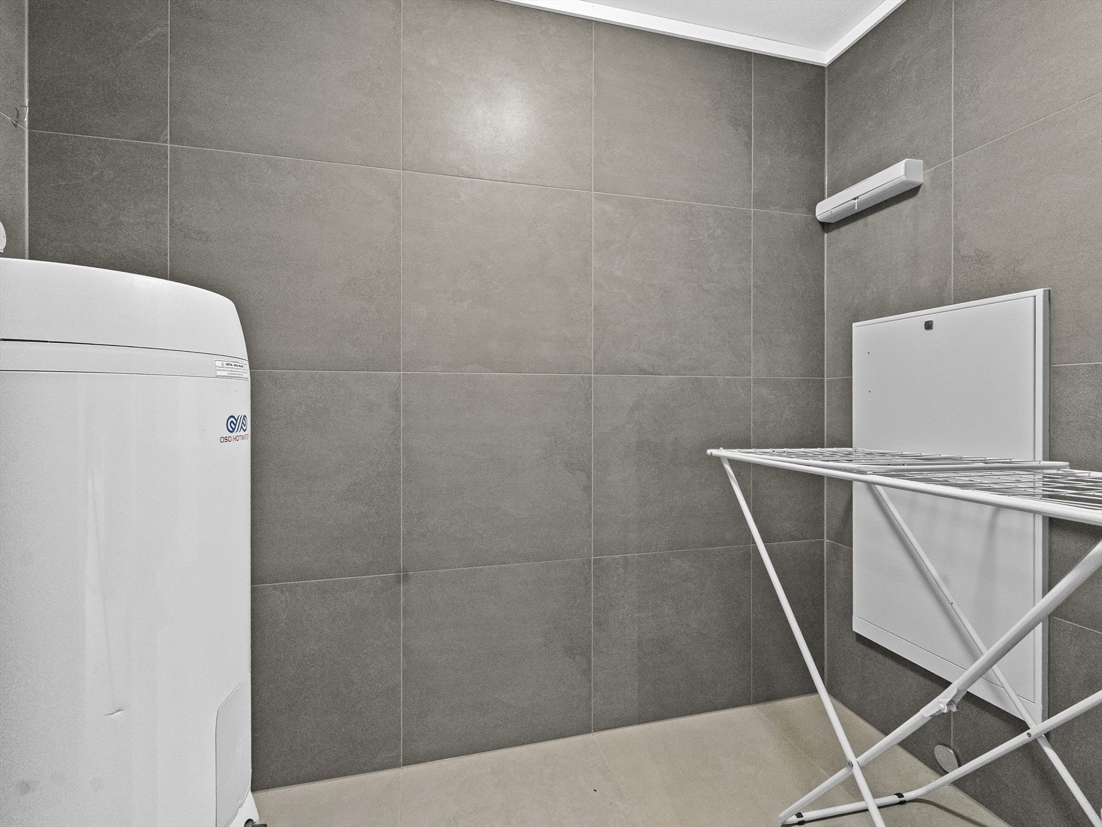 Praktisk fliselagt vaskerom med tørkeplass. Galleribilde