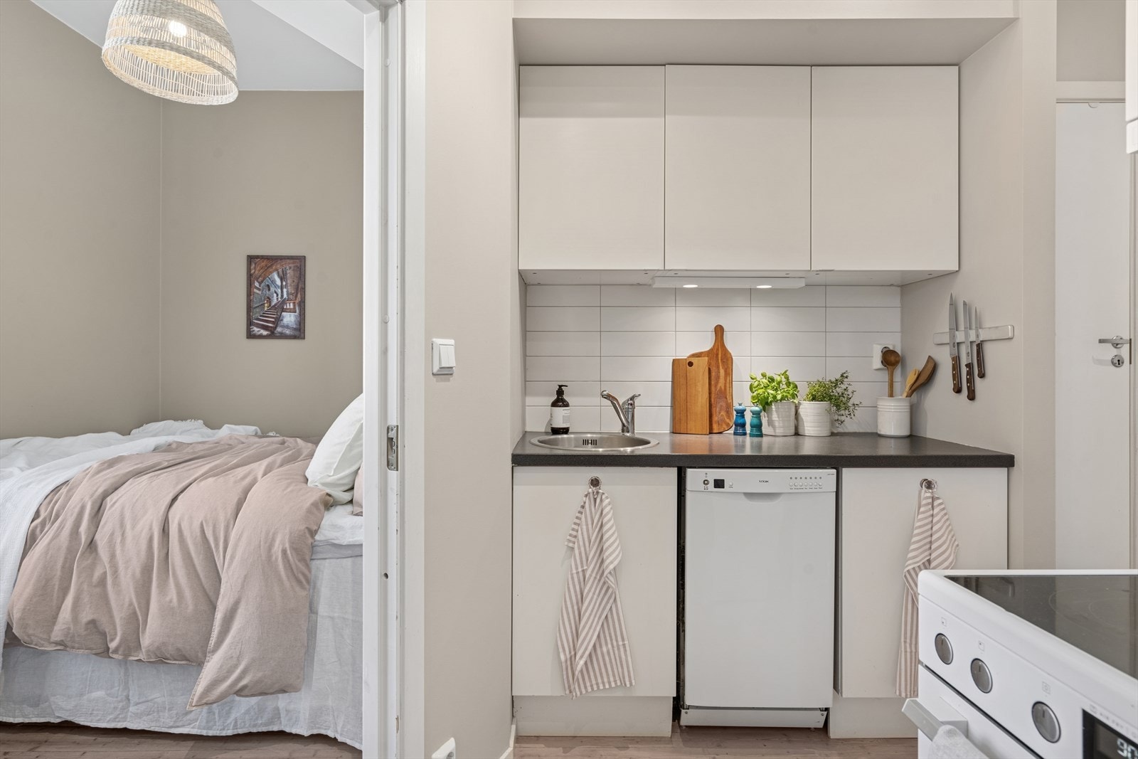 Kjøkkenet er utstyrt med hvitevarer som komfyr, oppvaskmaskin og kjøleskap med frysedel Galleribilde