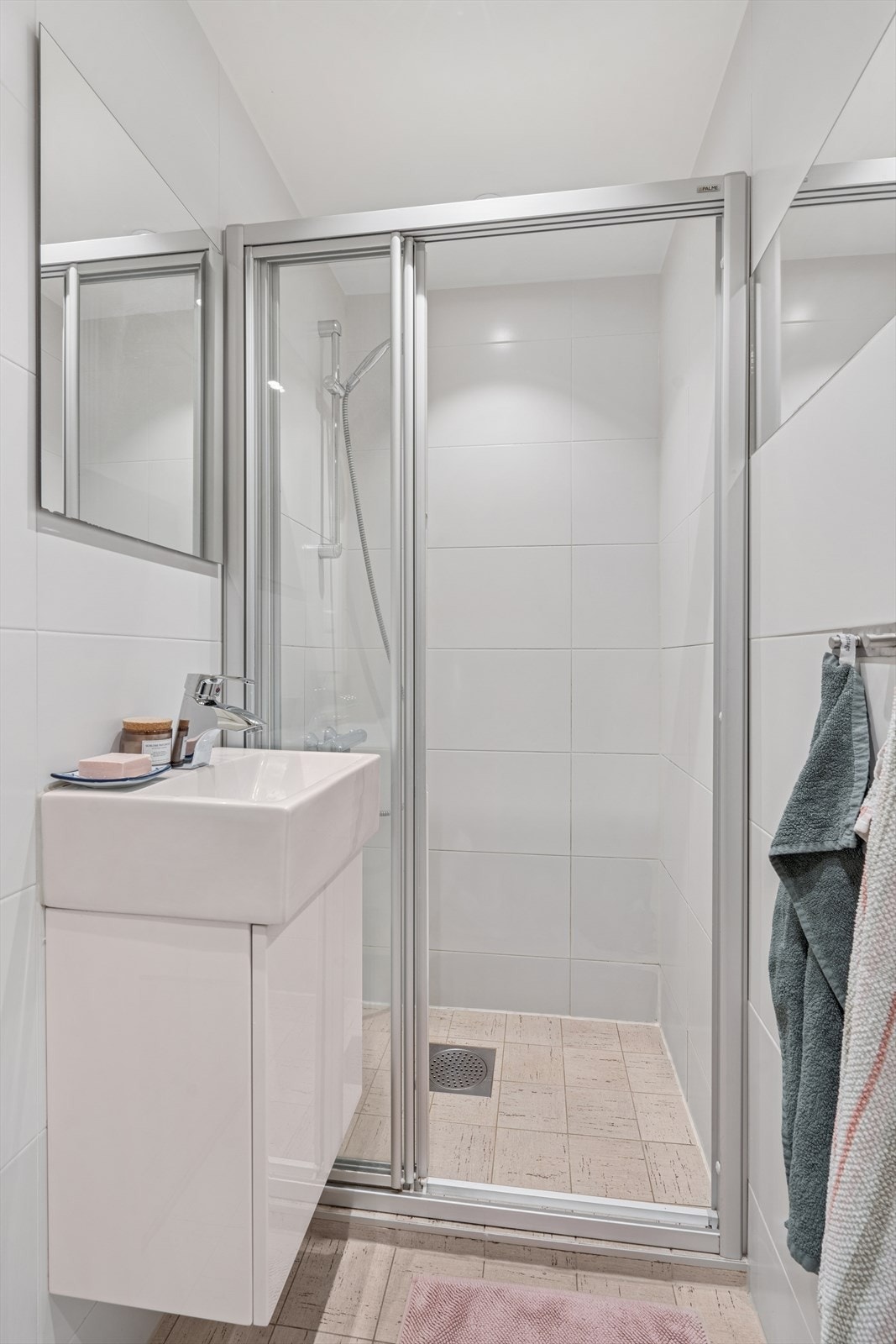 Stilrent bad med flislagte gulv og vegger, samt en glatt, sparklet og malt himling Galleribilde