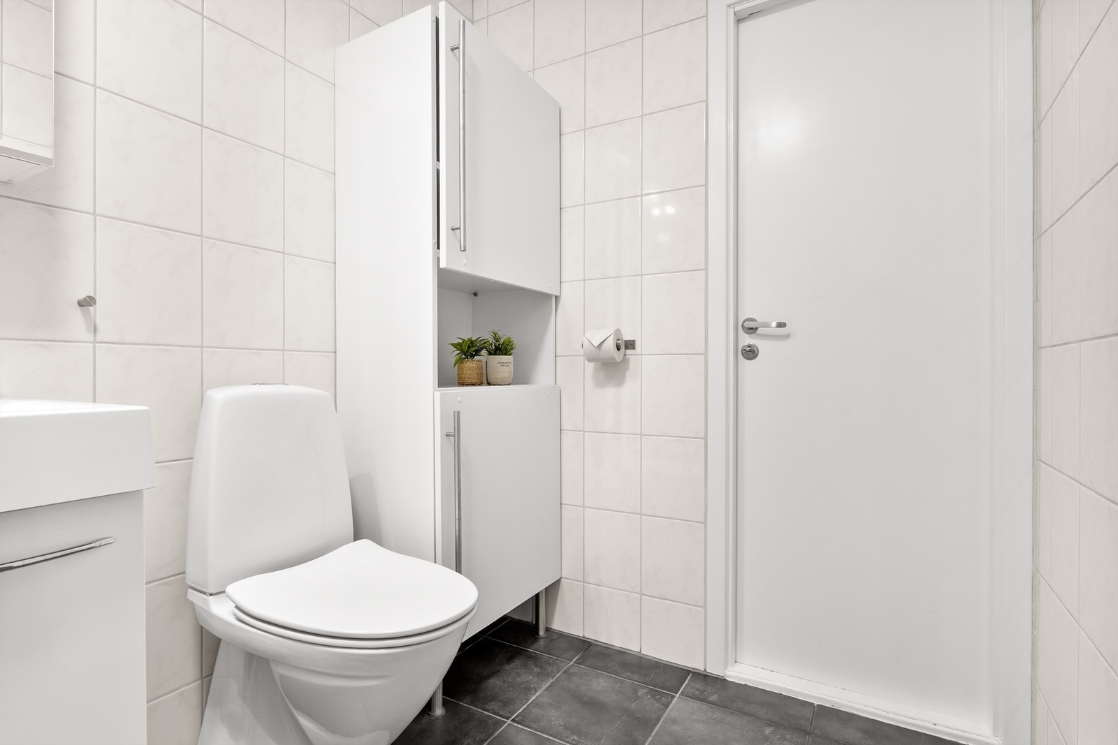 På badet er det vegghengt servantinnredning, speil med overlys, badekar med vegghengt badekararmatur og gulvstående toalett. Galleribilde