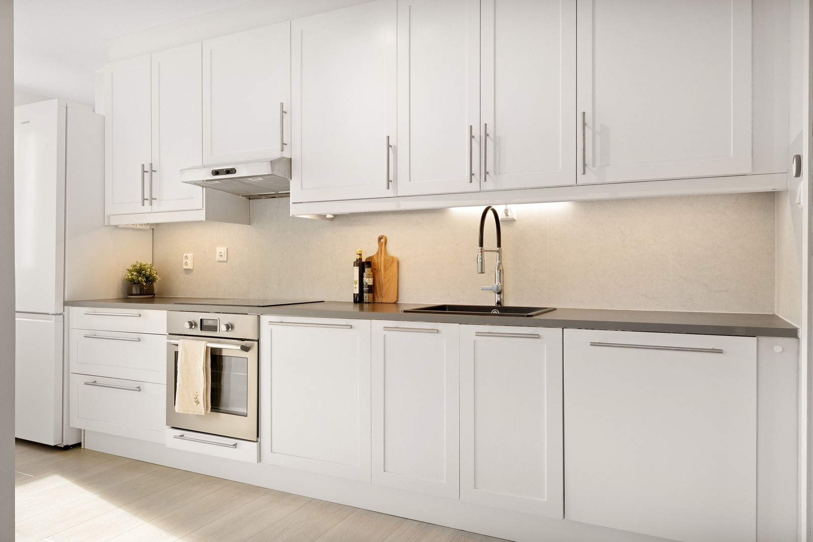 Lyst og innbydende kjøkken med god lagringsplass. Innredning med profilerte fronter og benkeplate av laminat. Galleribilde