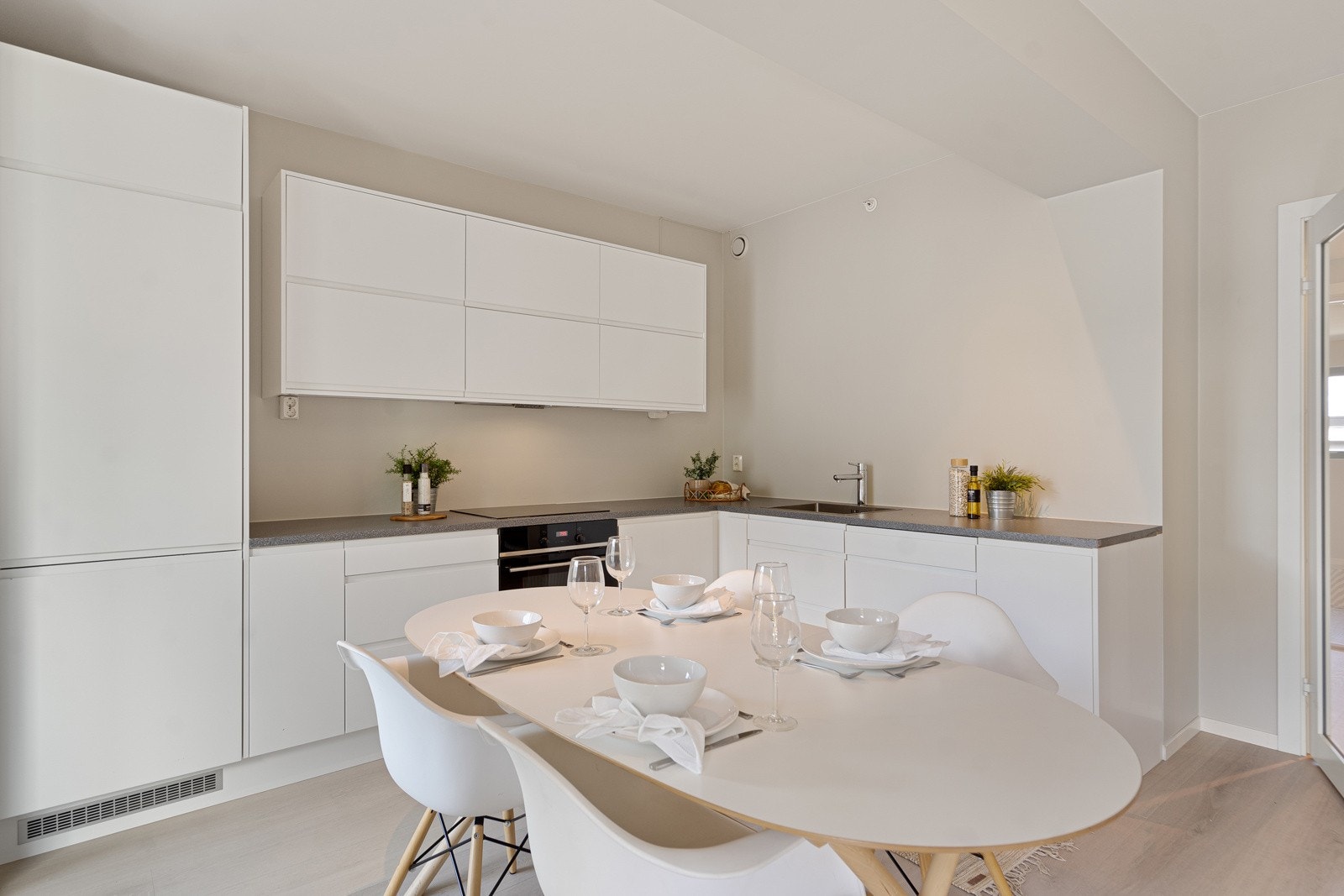 Lyst og pent kjøkken med godt med skap- og benkeplass Galleribilde