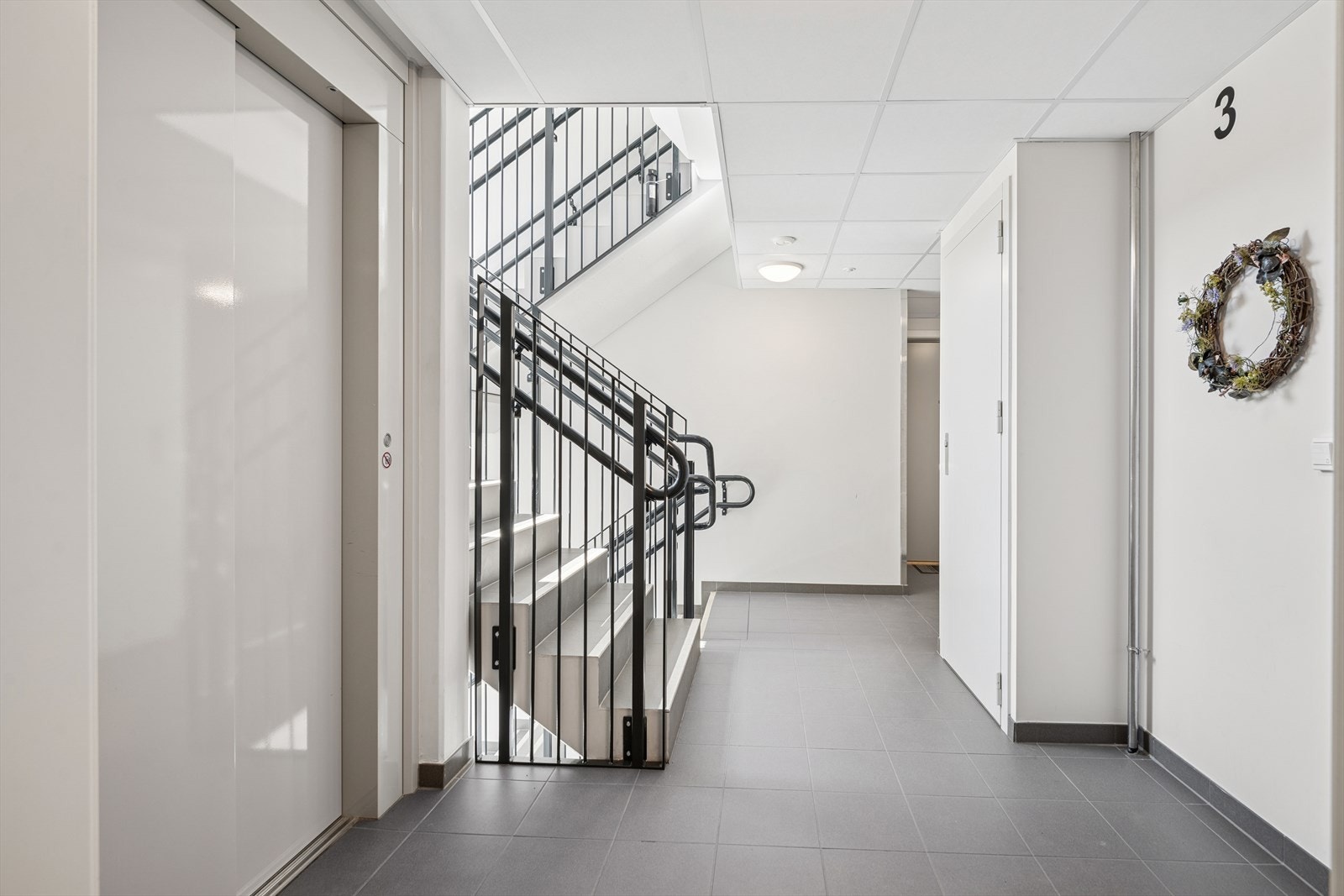 Lys og romslig gang med enkel tilgang til heis, som gir praktisk bevegelse mellom etasjene. Galleribilde