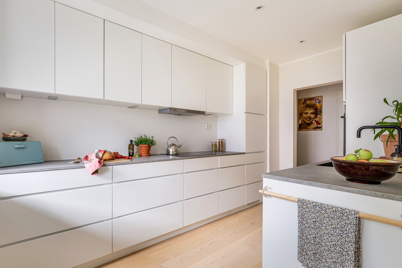 Kjøkkeninnredningen er fra 2021 fra kvalitetsprodusenten Kvik med hvite glatte fronter og fin, grå laminat benkeplate. Galleribilde