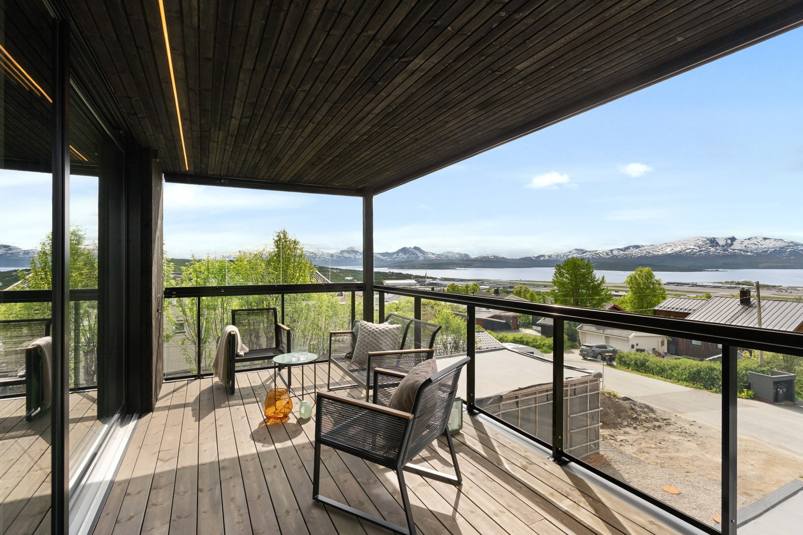 En stor innglasset balkong med utgang fra stuen - vender mot sør og vest med panoramautsikt over fjorden.