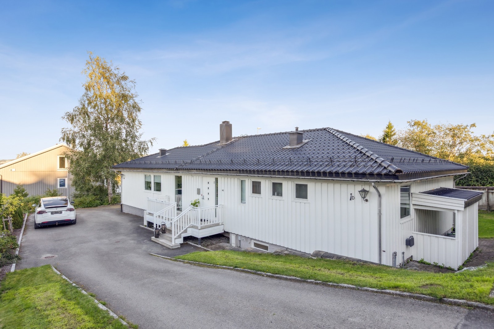 Asfaltert gårdsplass i enden av veien så ingen trafikk går forbi husets inngangsparti. Galleribilde