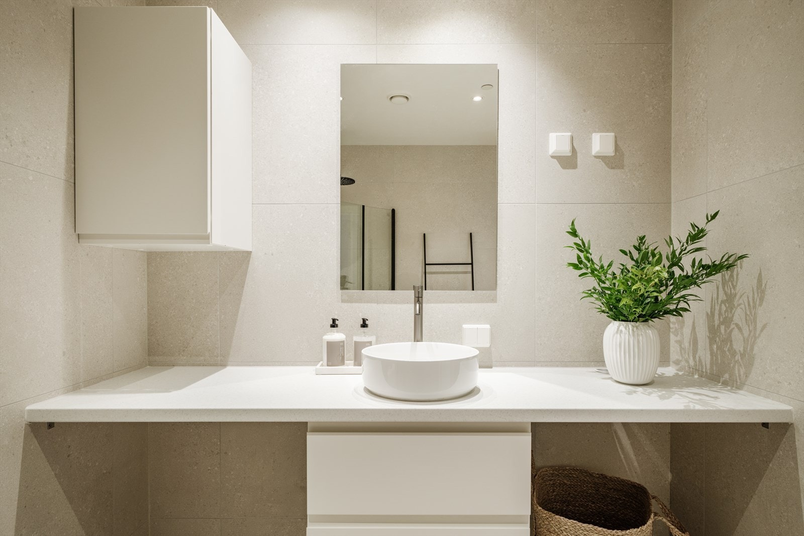 Rommet er innredet med toalett, dusjhjørne med svingbare glassdører og baderomsinnredning med skuffer, servant og speil. Badet fikk ny vask, armatur og benkeplate i 2025. Det er opplegg for vaskemaskin. Galleribilde