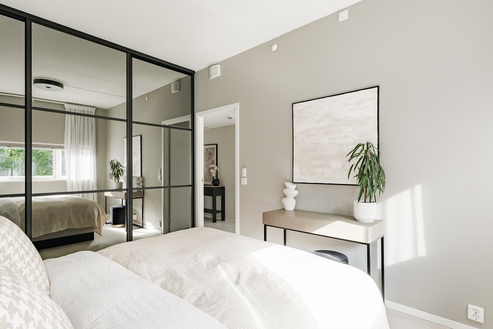 Det er innholdsrik skyvedørsgarderobe med speilfronter langs den ene veggen. Galleribilde