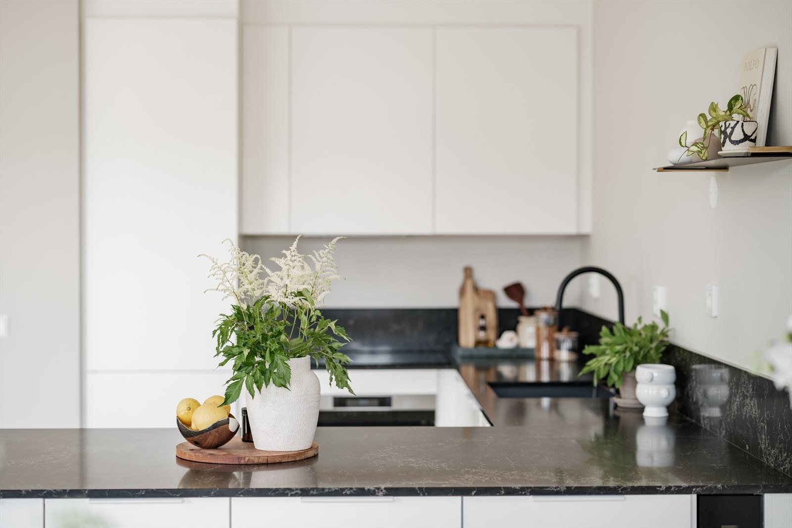 Tidsriktig innredning med hvite, glatte fronter og benkeplate i stein fra Sigvartsen Steinindustri. Galleribilde