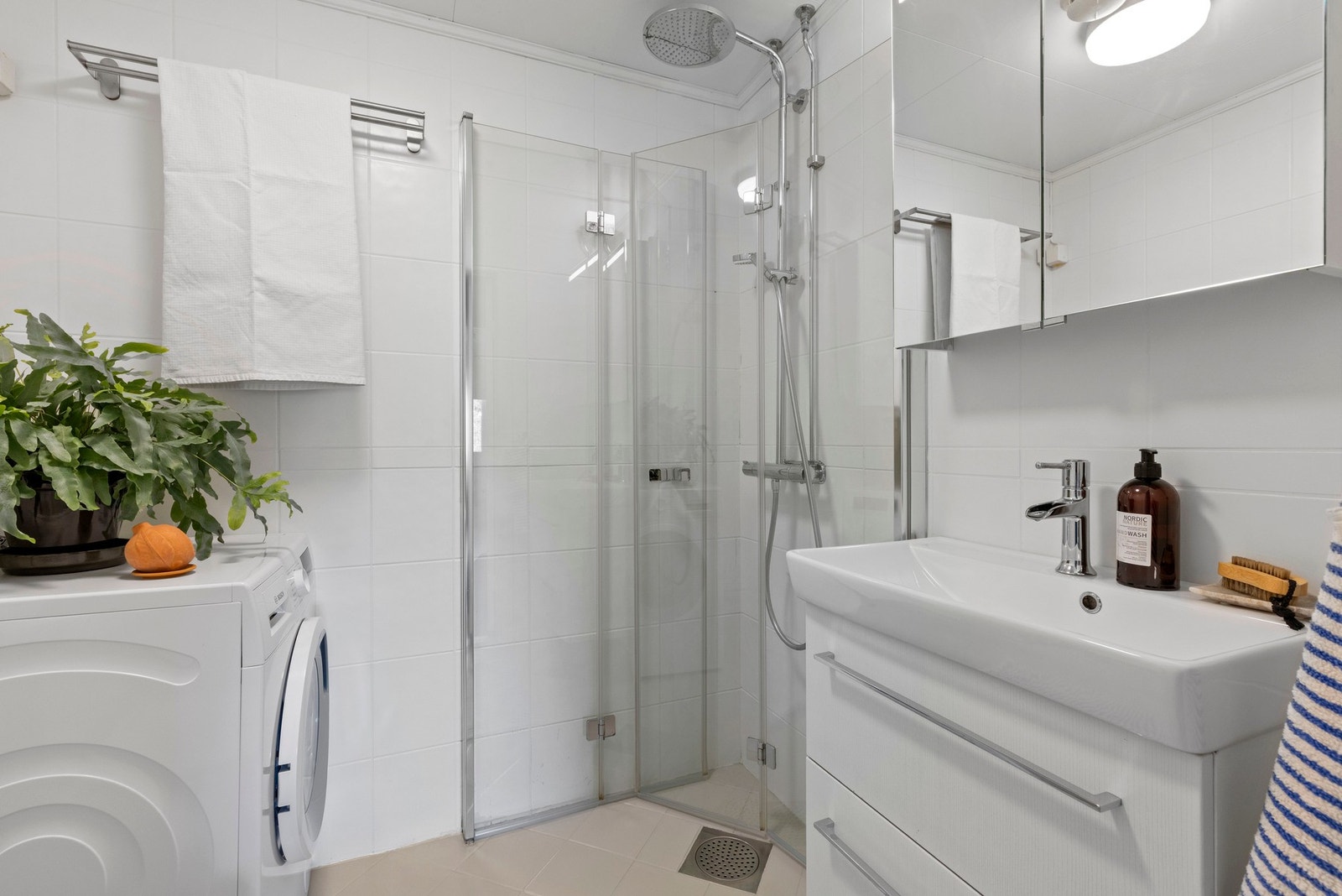 Badet er delikat med flislagte overflater, som gir et rent uttrykk Galleribilde