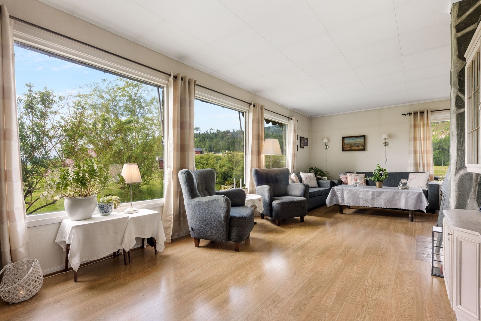 Stuen er romslig og har store vinduer med mye lysinnslipp og utsikt mot naturen. Galleribilde