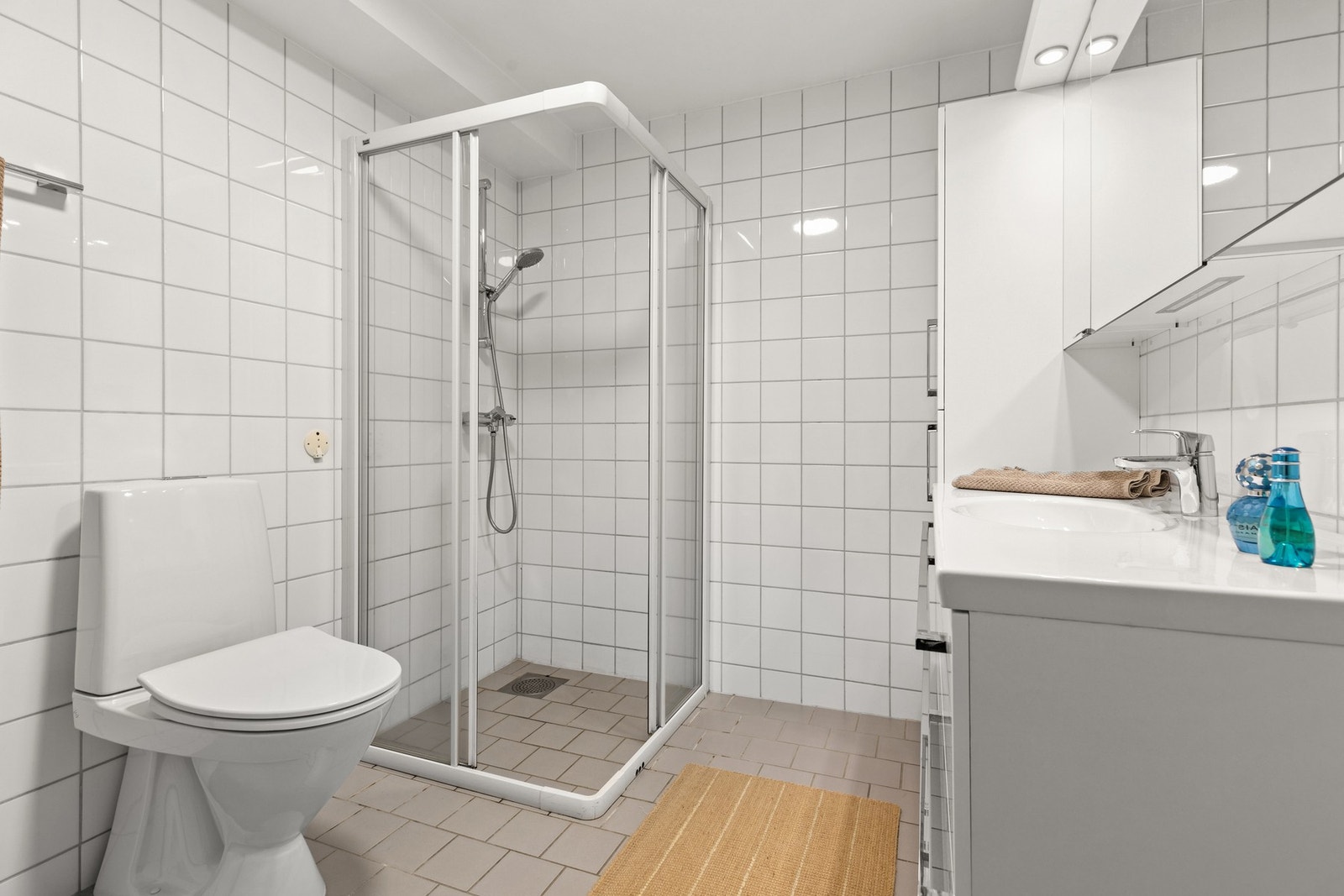 Badet inkluderer gulvstående toalett, dusjhjørne og opplegg for vaskemaskin. Galleribilde
