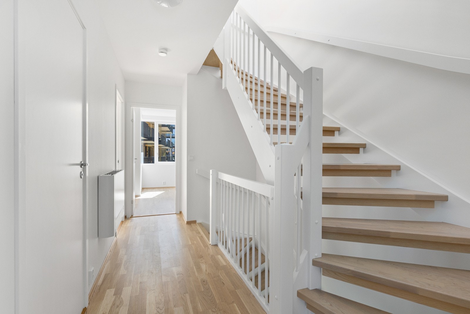 Lyse overflater gir en romslig følelse i gang og trapp Galleribilde