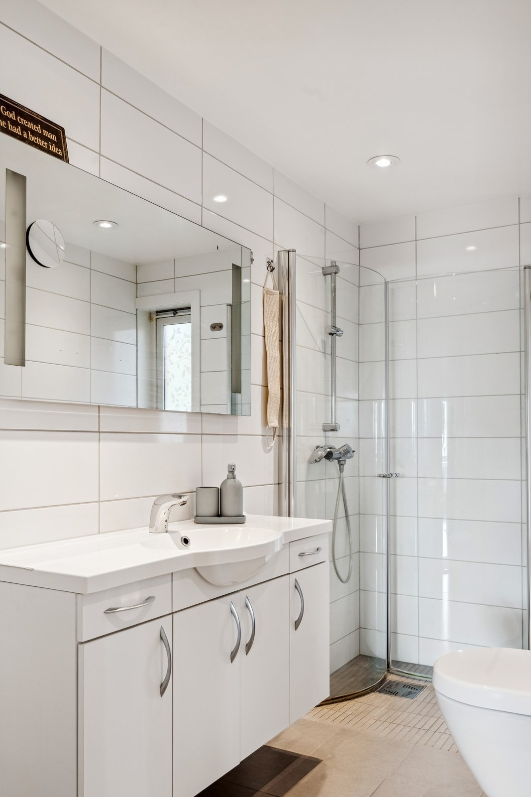Badet er innredet med flislagte overflater, wc, og dusjhjørne med innfellbare dører. Galleribilde
