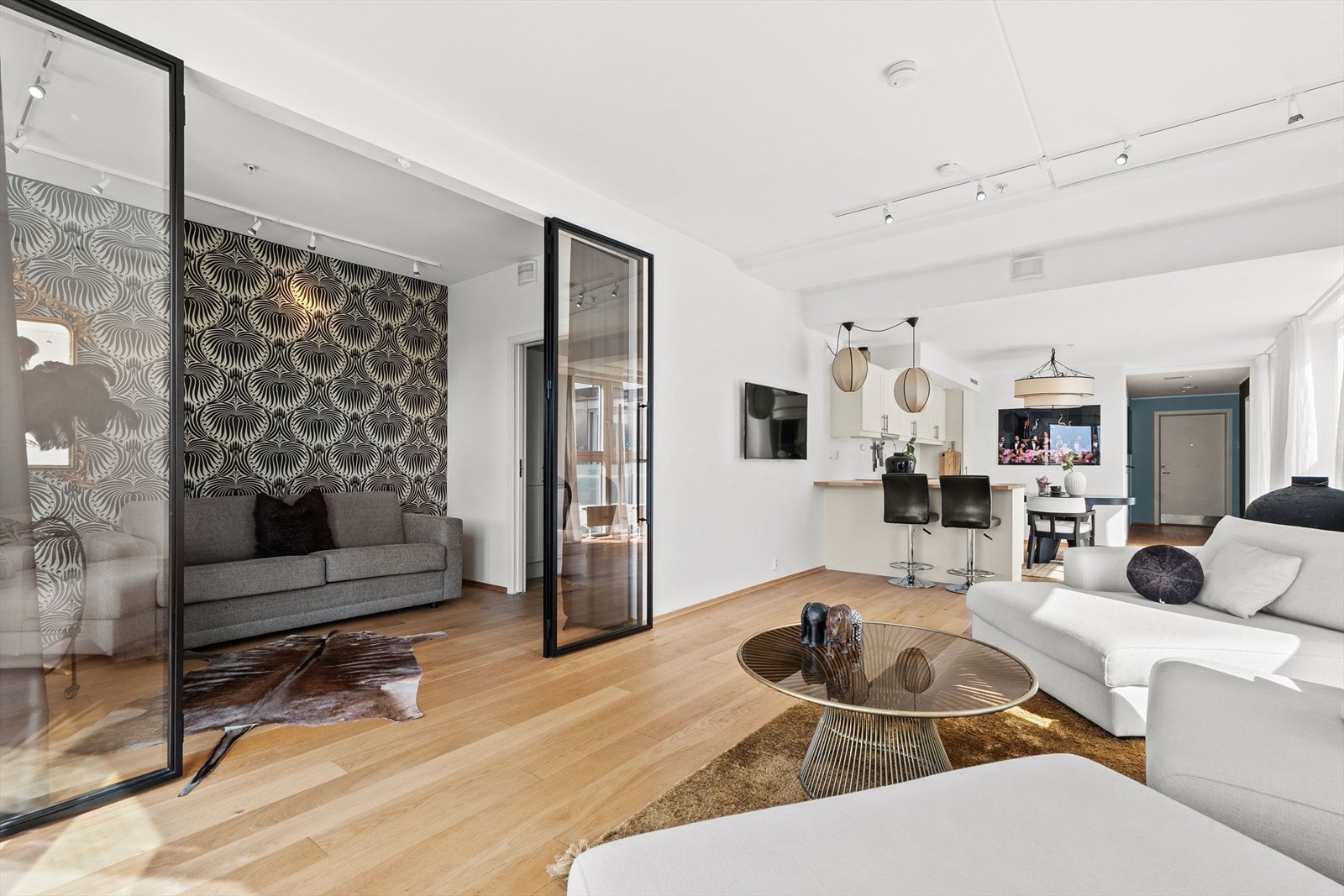 Glassvegg med doble dører skaper en åpen og luftig overgang mellom stue og soverom Galleribilde