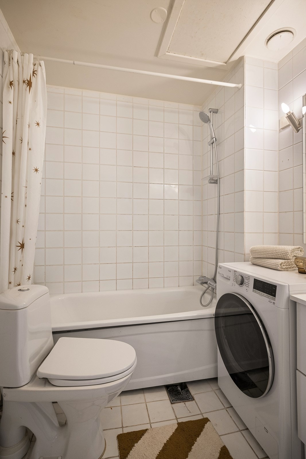 Eldre flislagt bad med gulvvarme og opplegg for vaskemaskin. Galleribilde