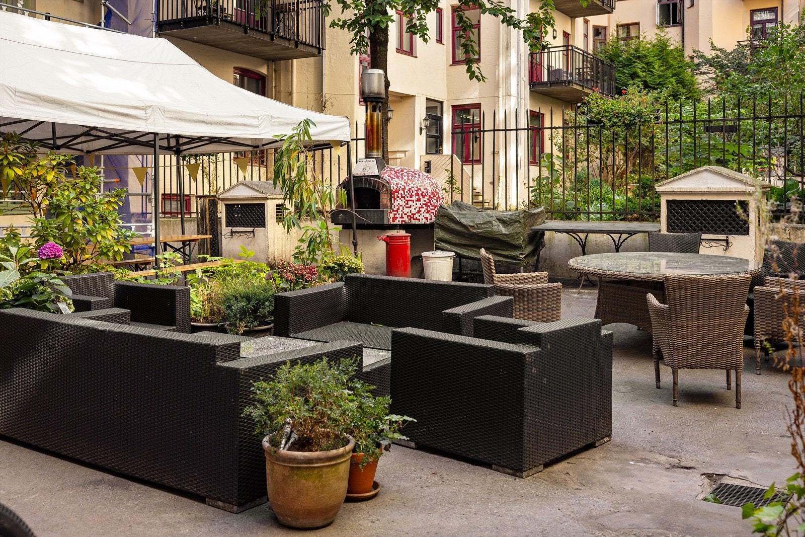 Hyggelig bakgård med sittegrupper og grill. Galleribilde