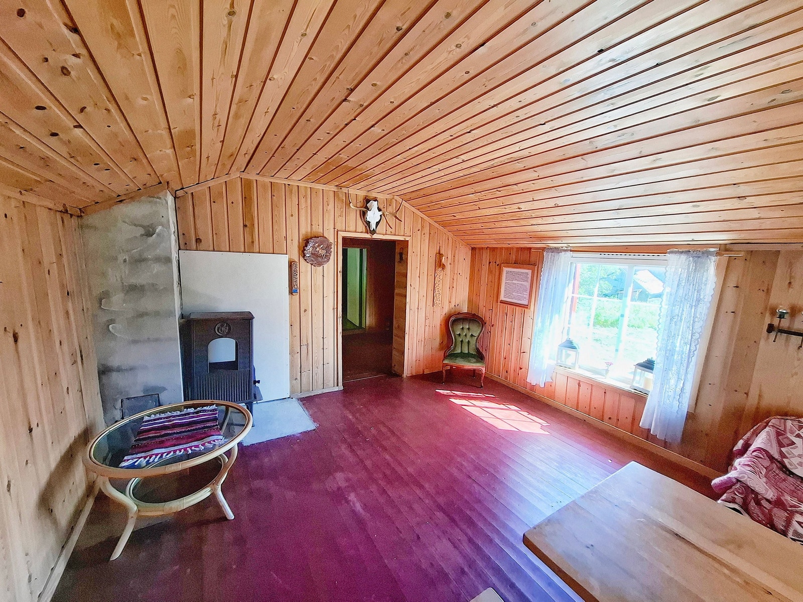 Stue med vedovn og stort vindu som slipper inn godt med naturlig lys. Galleribilde