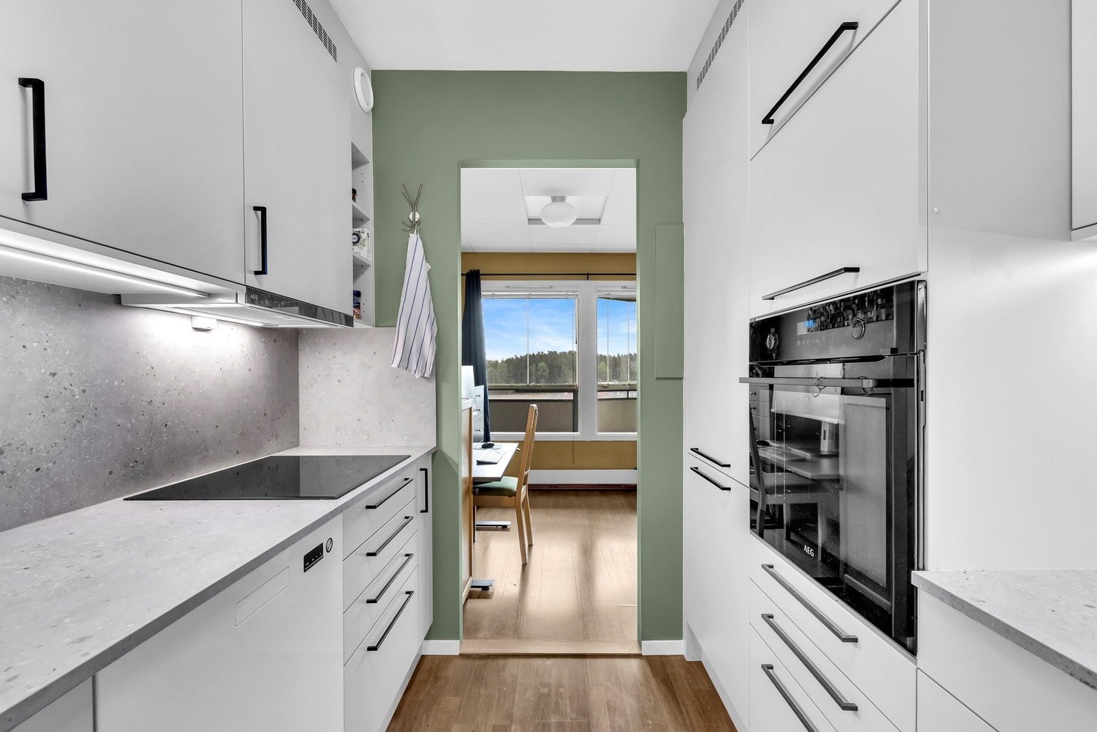 Kjøkkenet ligger praktisk til med adkomst fra stuen, og byr på en stilren innredning med slette fronter fra 2024. Galleribilde