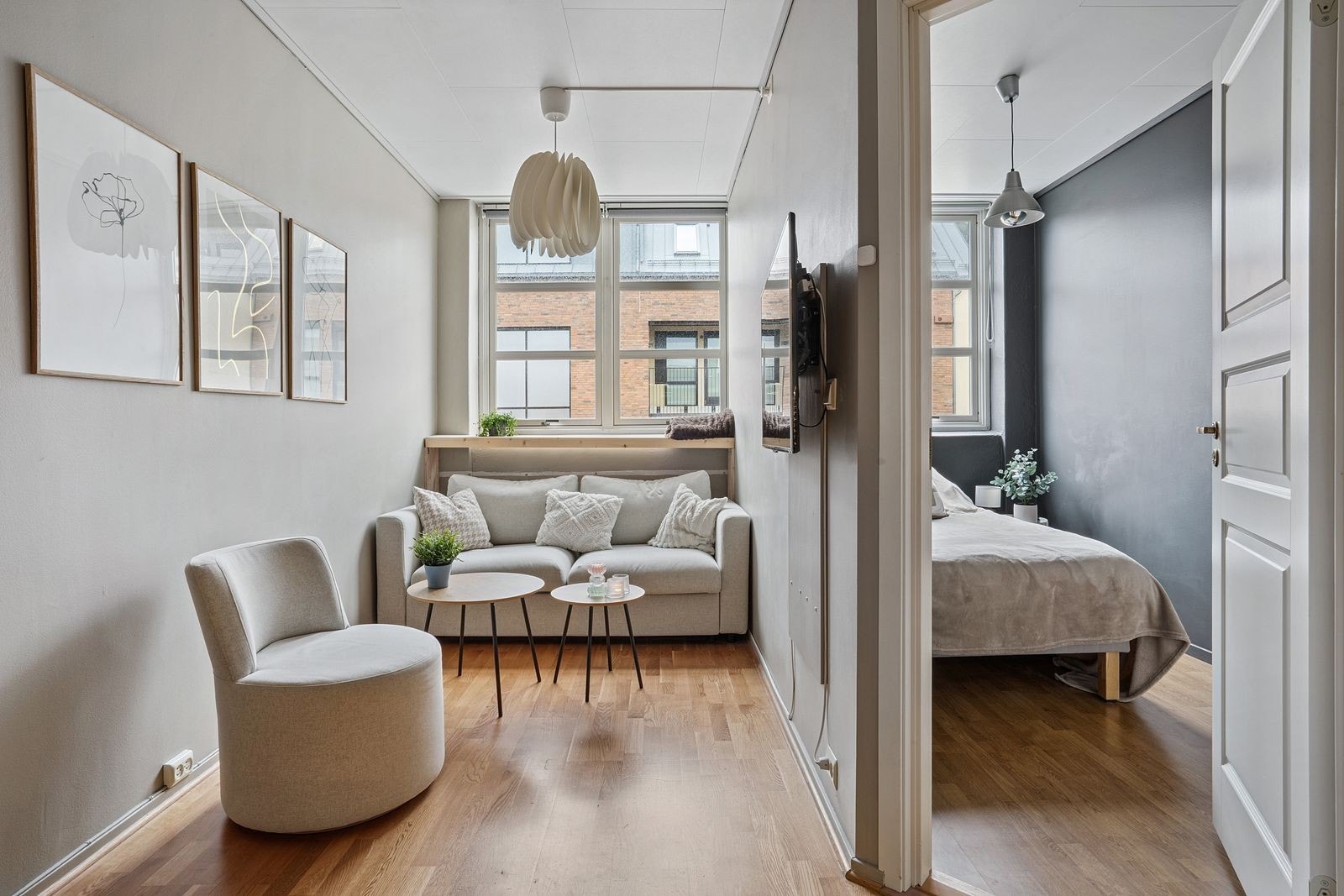 Store vindusposter gir godt med lysinnslipp til stuen. Her har man plass til koselig sofagruppe. Galleribilde