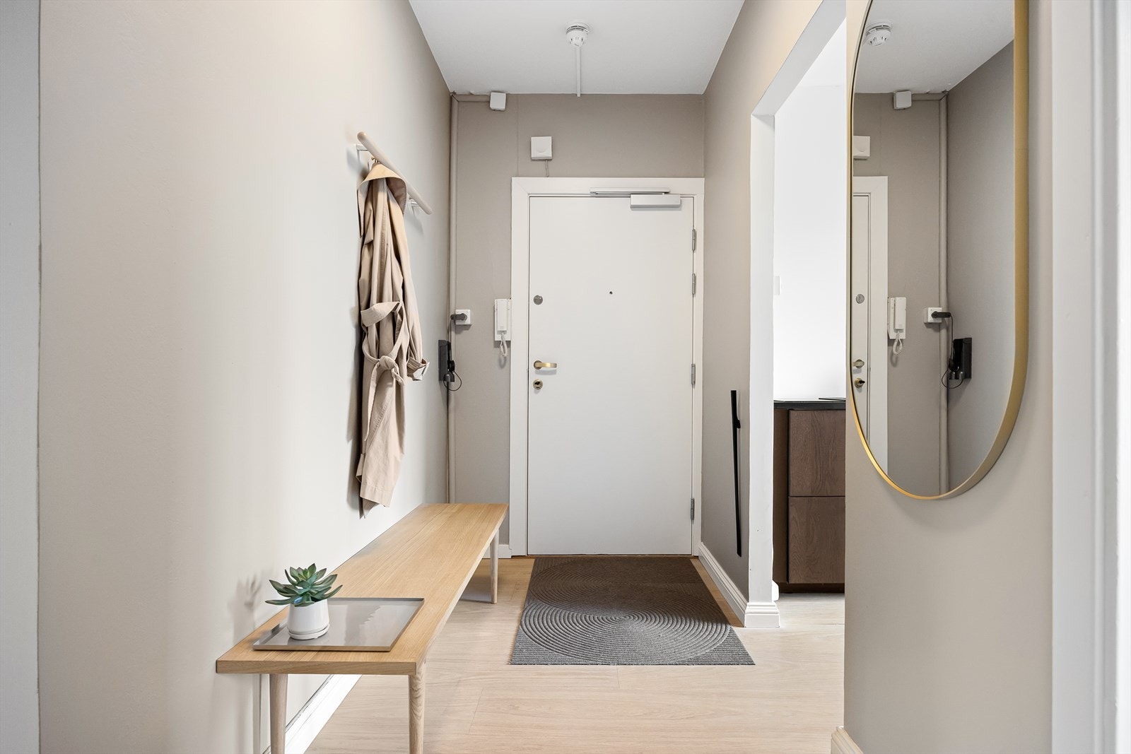 Velkommen inn! Leiligheten har en innbydende entré som skaper et umiddelbart godt førsteinntrykk. Her kan du enkelt henge i fra deg yttertøy. Galleribilde