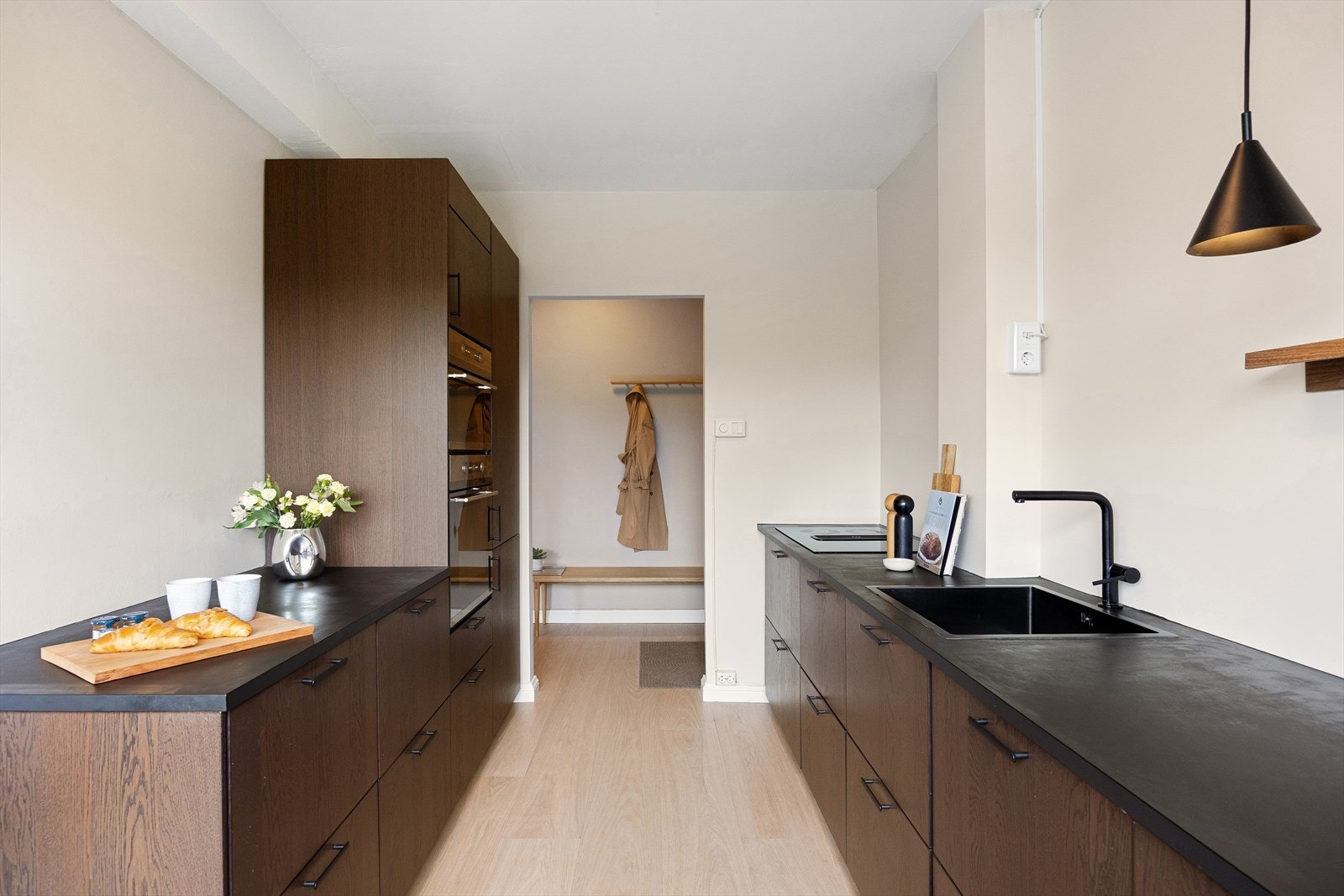 Benkeplaten er av laminat med en nedfelt vaskekum og belysning over benkeplaten. Galleribilde