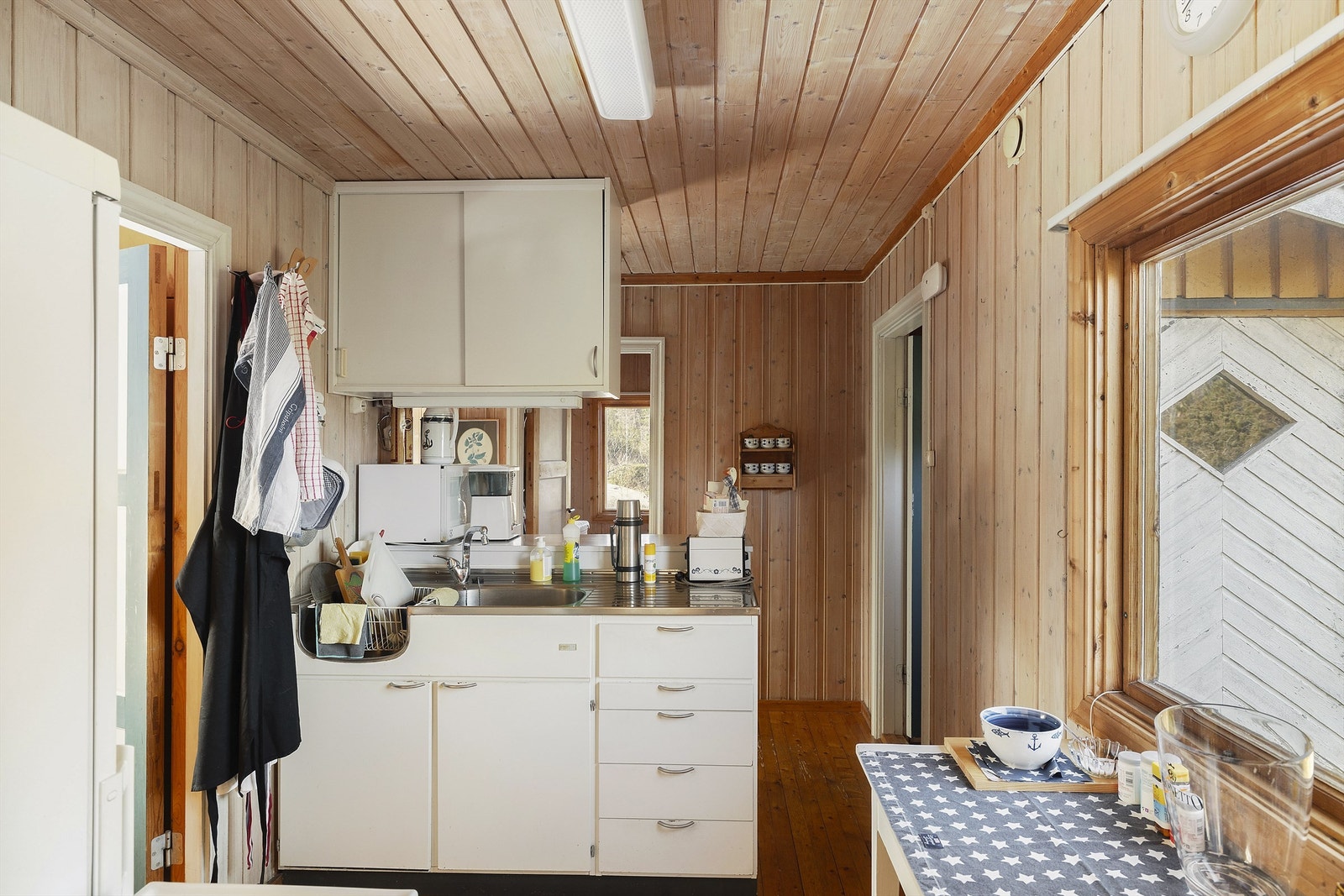 Kjøkkenet er kompakt og enkelt, men lyst og trivelig - en praktisk løsning. Galleribilde